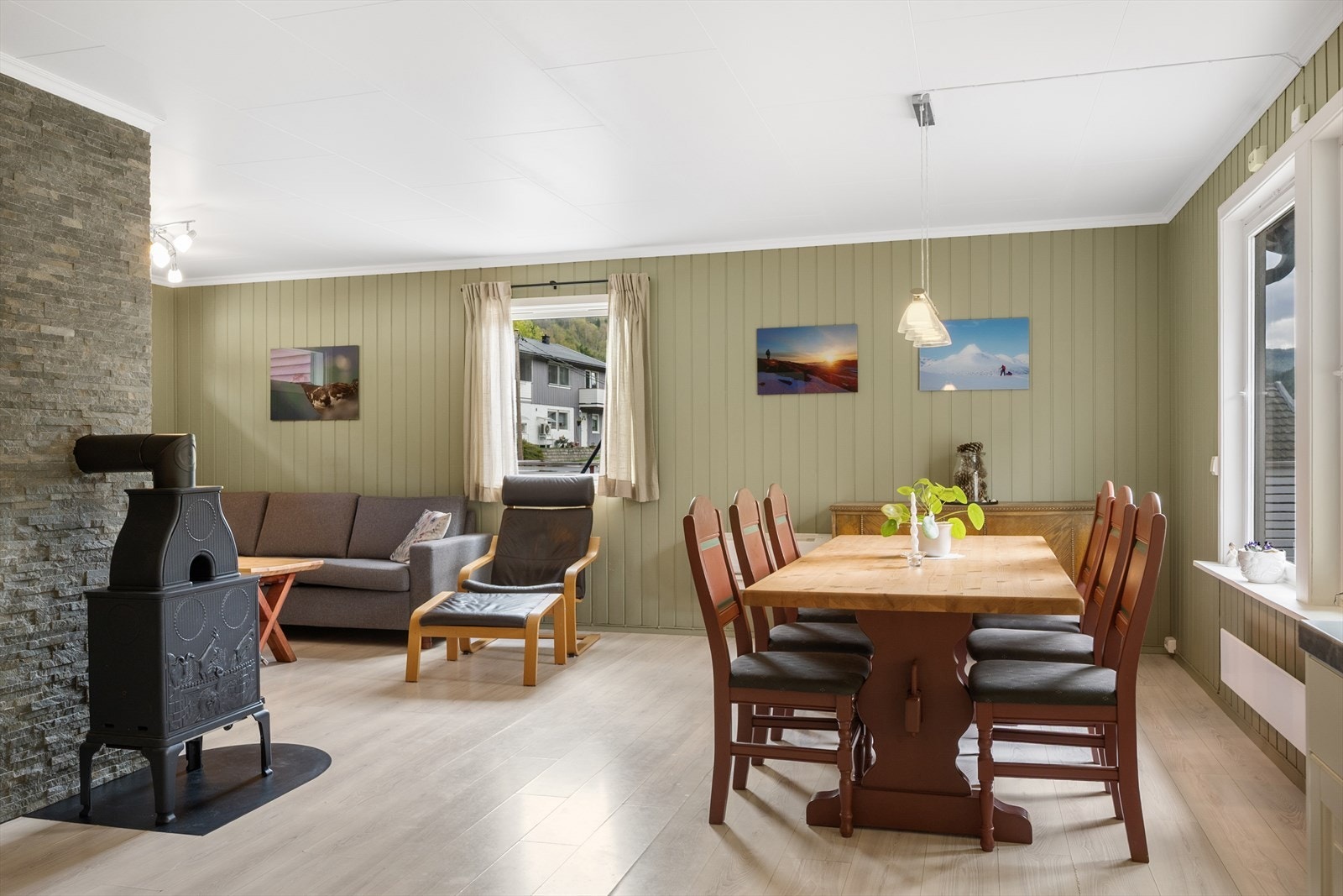 Stuen er malt i en lun grønnfarge, og det er plass til både sofagruppe og spisestue. Galleribilde