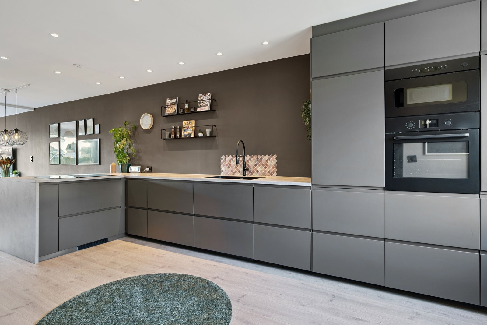 Integrerte hvitevarer og kjøkkenvifte nedfelt ved stekeplatene Galleribilde