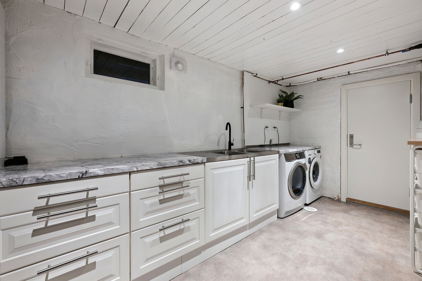 Romslig vaskerom med godt av lagringsplass Galleribilde