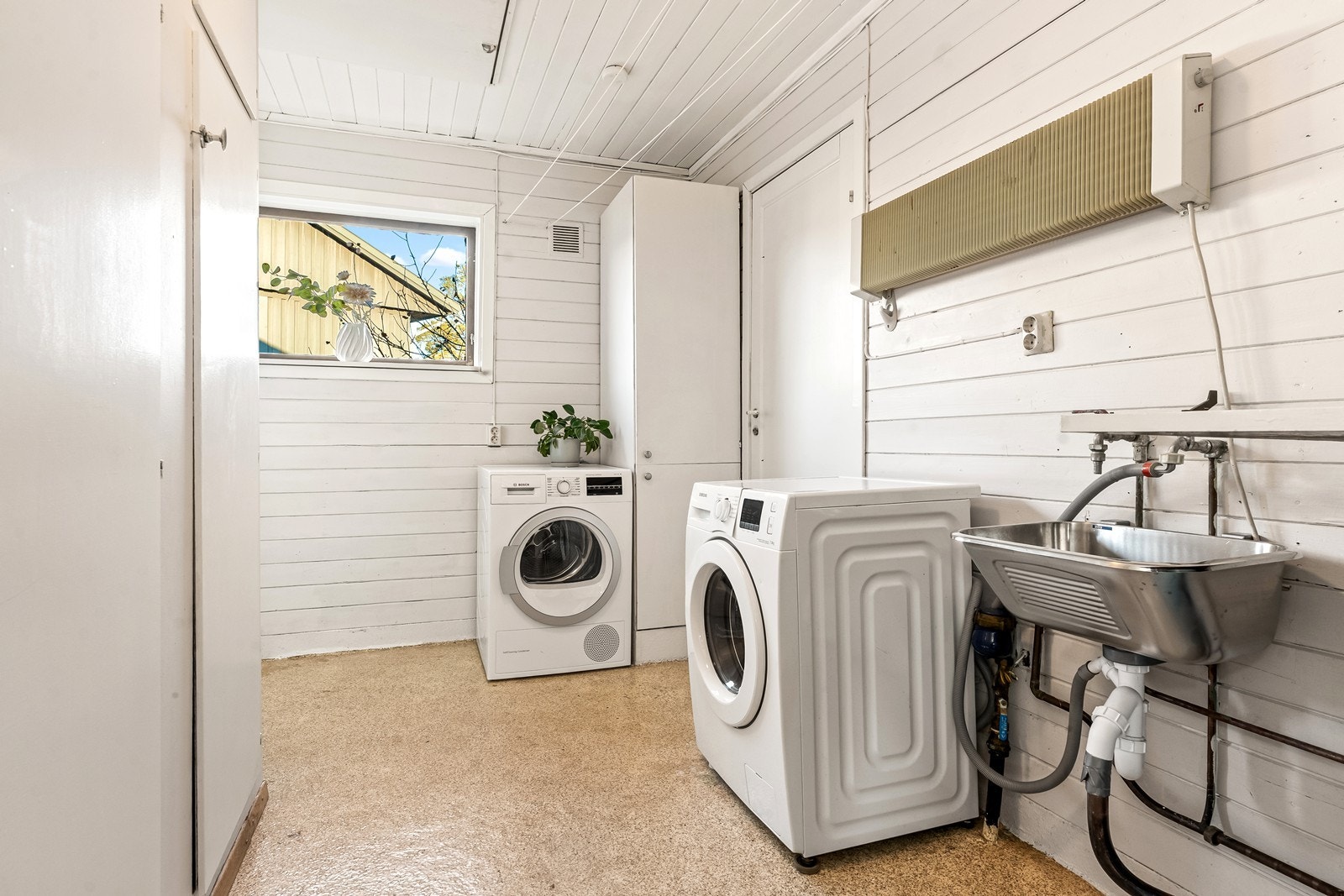 Separat vaskerom med opplegg for vaskemaskin og tørketrommel, samt utslagsvask. Galleribilde