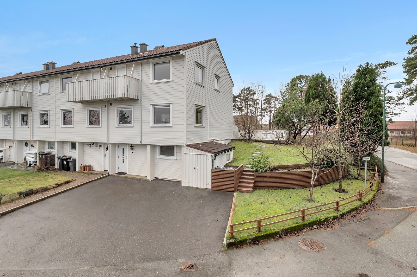 Enderekkehus med stor innkjørsel og pen hage med diverse beplantninger Galleribilde