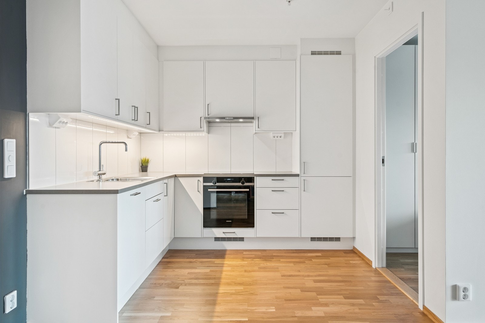 Stilrent hvitt kjøkken med mye skapplass. Galleribilde