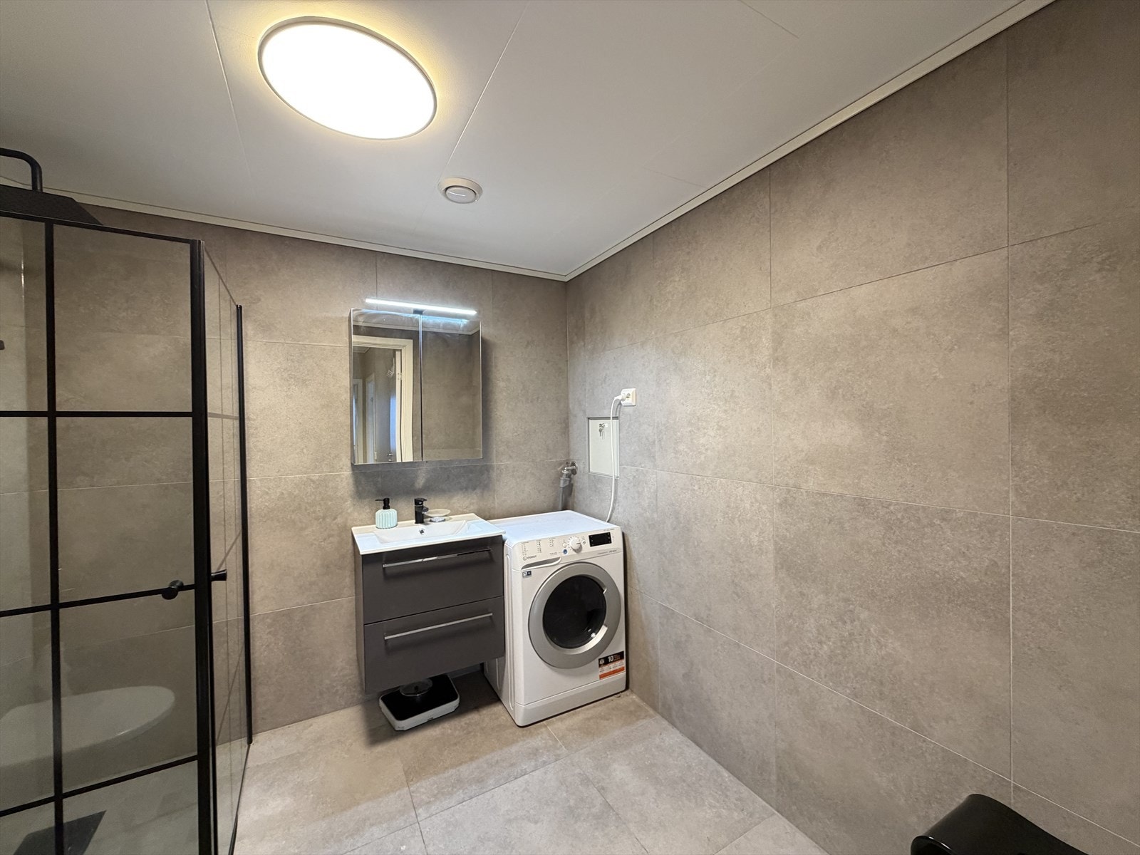 Den praktiske innredningen består av speilskap, nedsenket servant, dusjhjørne med glassvegger, samt gulvstående toalett. Det er også opplegg for vaskemaskin. Galleribilde