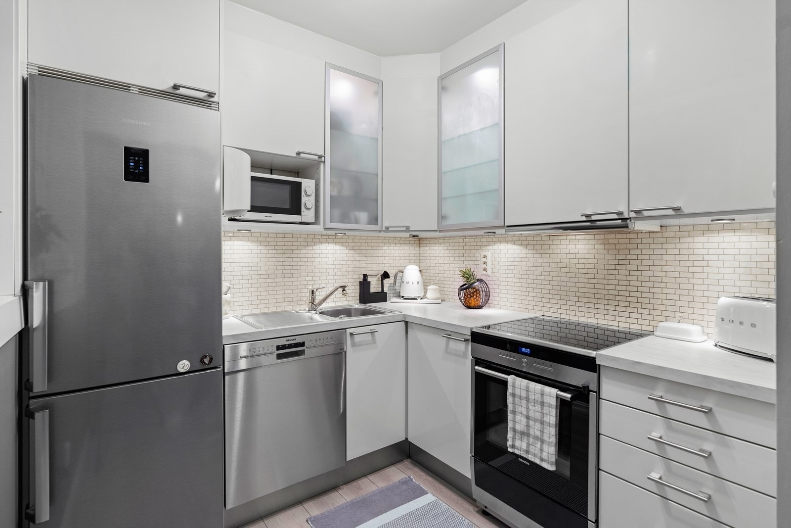 Kjøkkenskapene har glatte laminerte fronter og enkelte overskap med glassfronter. Galleribilde