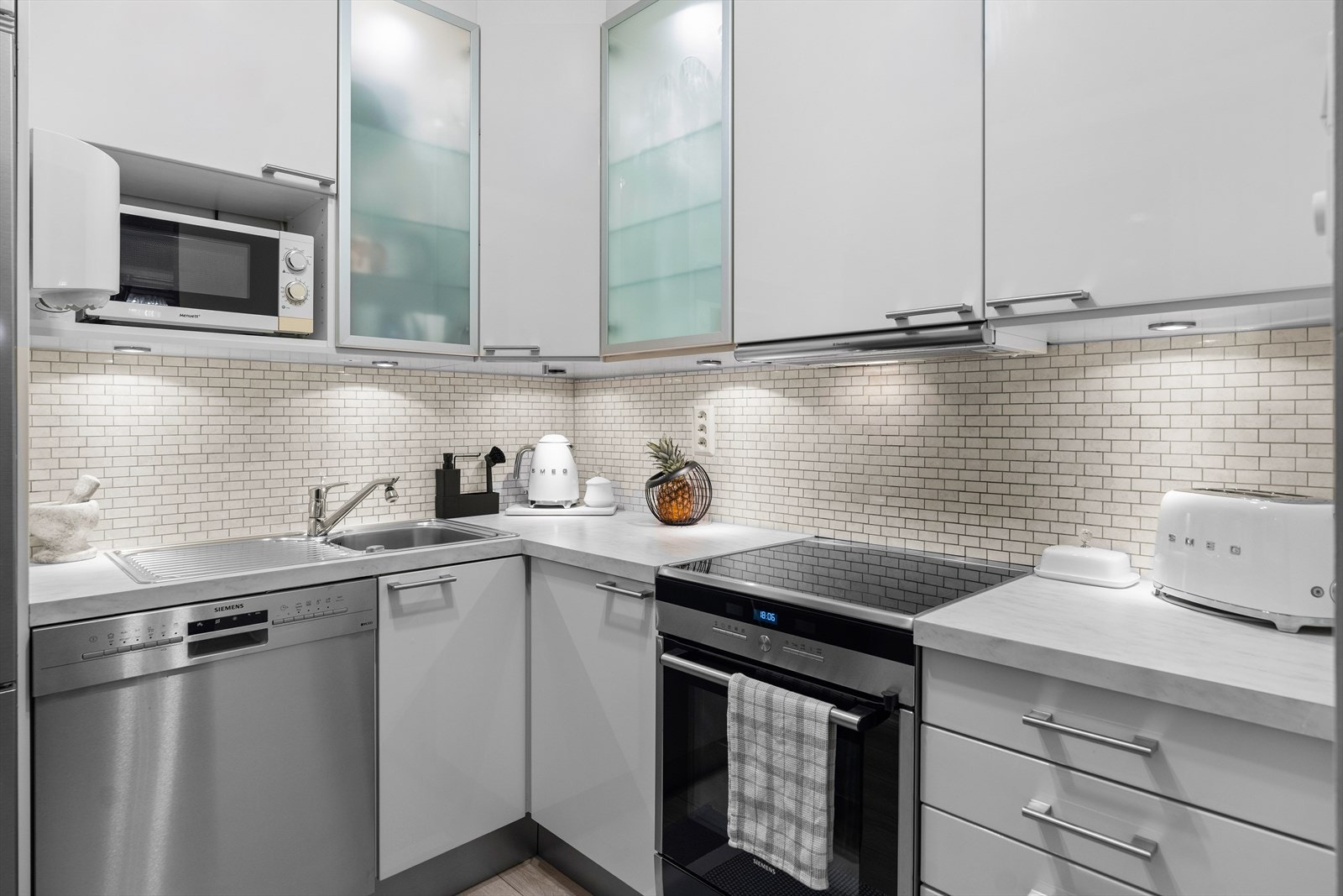 Videre er det laminert benkeplate med oppvaskkum i rustfritt stål med svingbart blandebatteri. Galleribilde