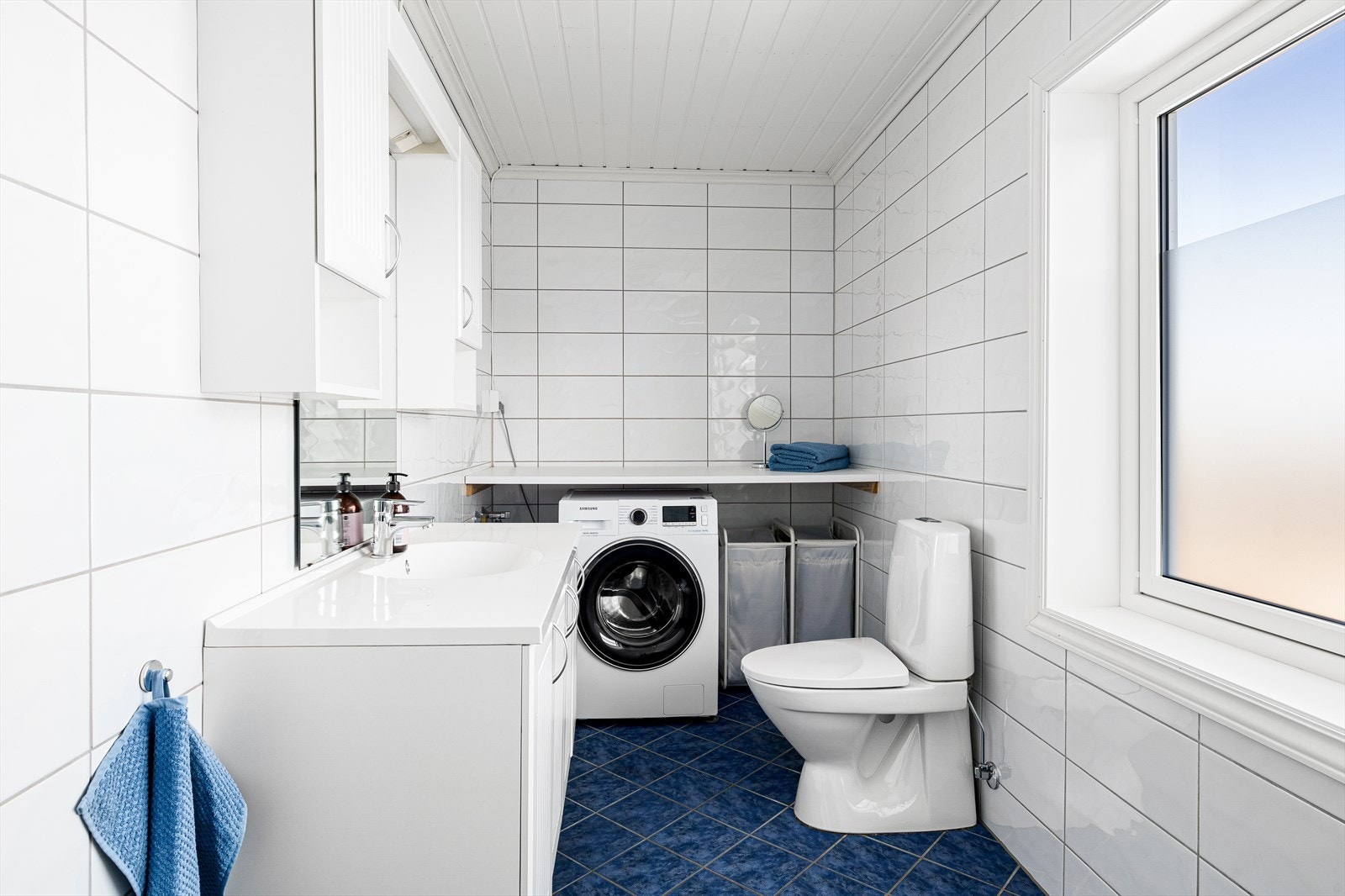 Pant bad/vaskerom i 2.etg. med flis på gulv og vegger samt malt himling. Inneholder dusjkabinett, baderommsinnredning med nedfelt servant, toalett og opplegg til vaskemaskin. Galleribilde