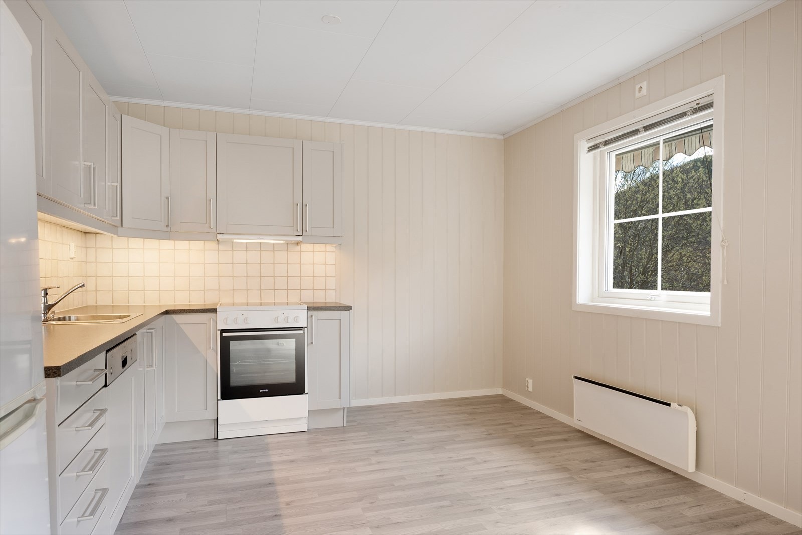 Den tidløse og lyse innredningen har profilerte fronter og benkeplate i laminat. Galleribilde