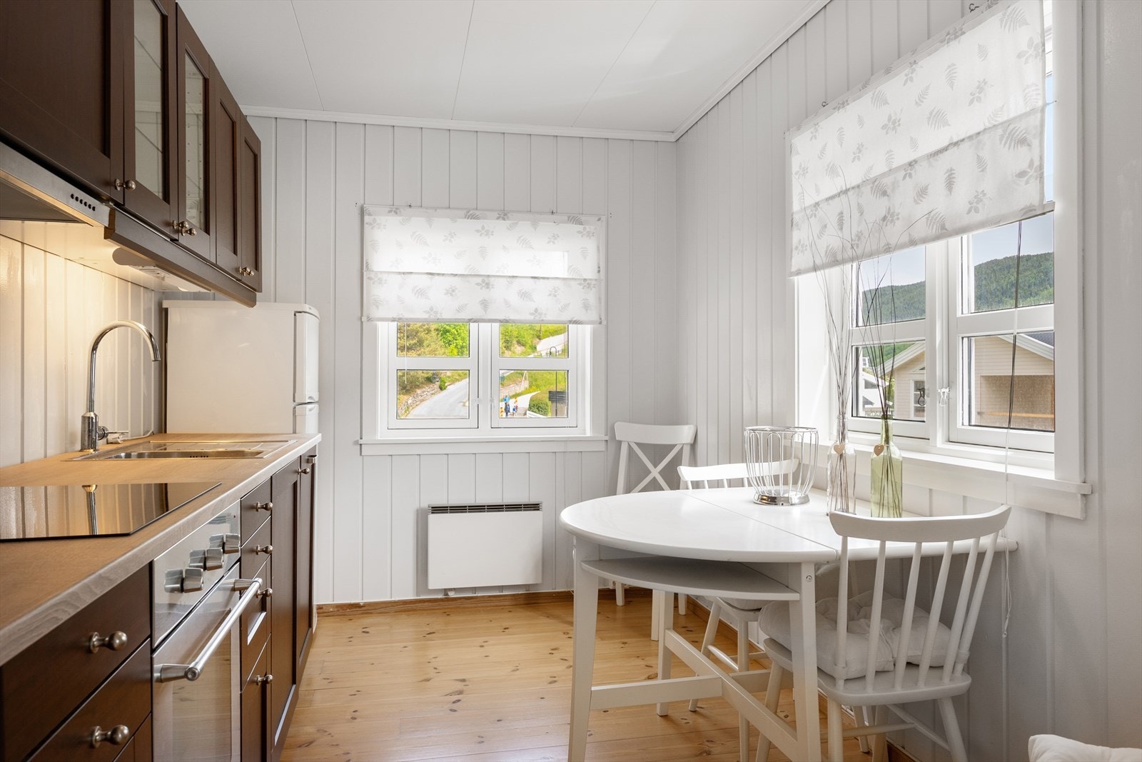 Kjøkkenet har en pen, mørkere innredning med benkeplate i laminat. Galleribilde