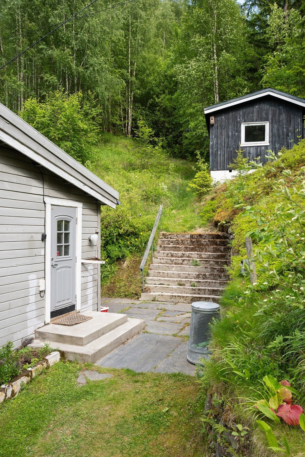 Inngangspartiet ligger på oversiden av eiendommen - herfra er det også trapp opp til uthuset. Galleribilde