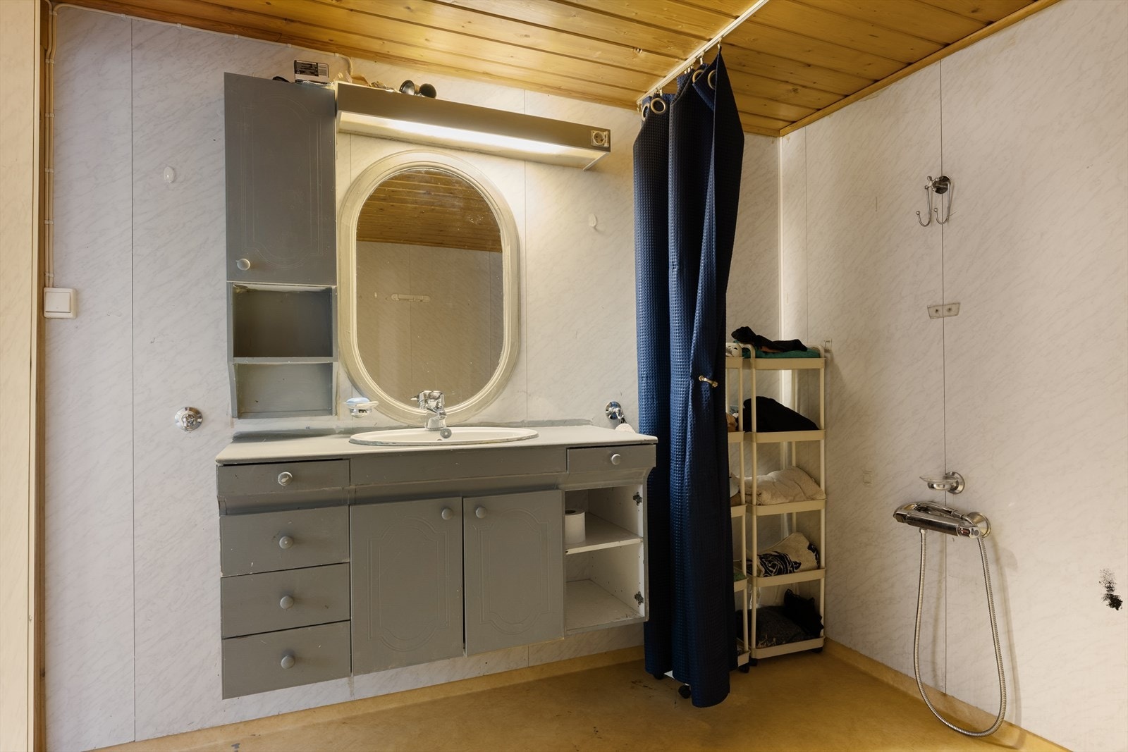 Badet har enkel standard og er innredet med skapinnredning og dusj med forheng. Galleribilde