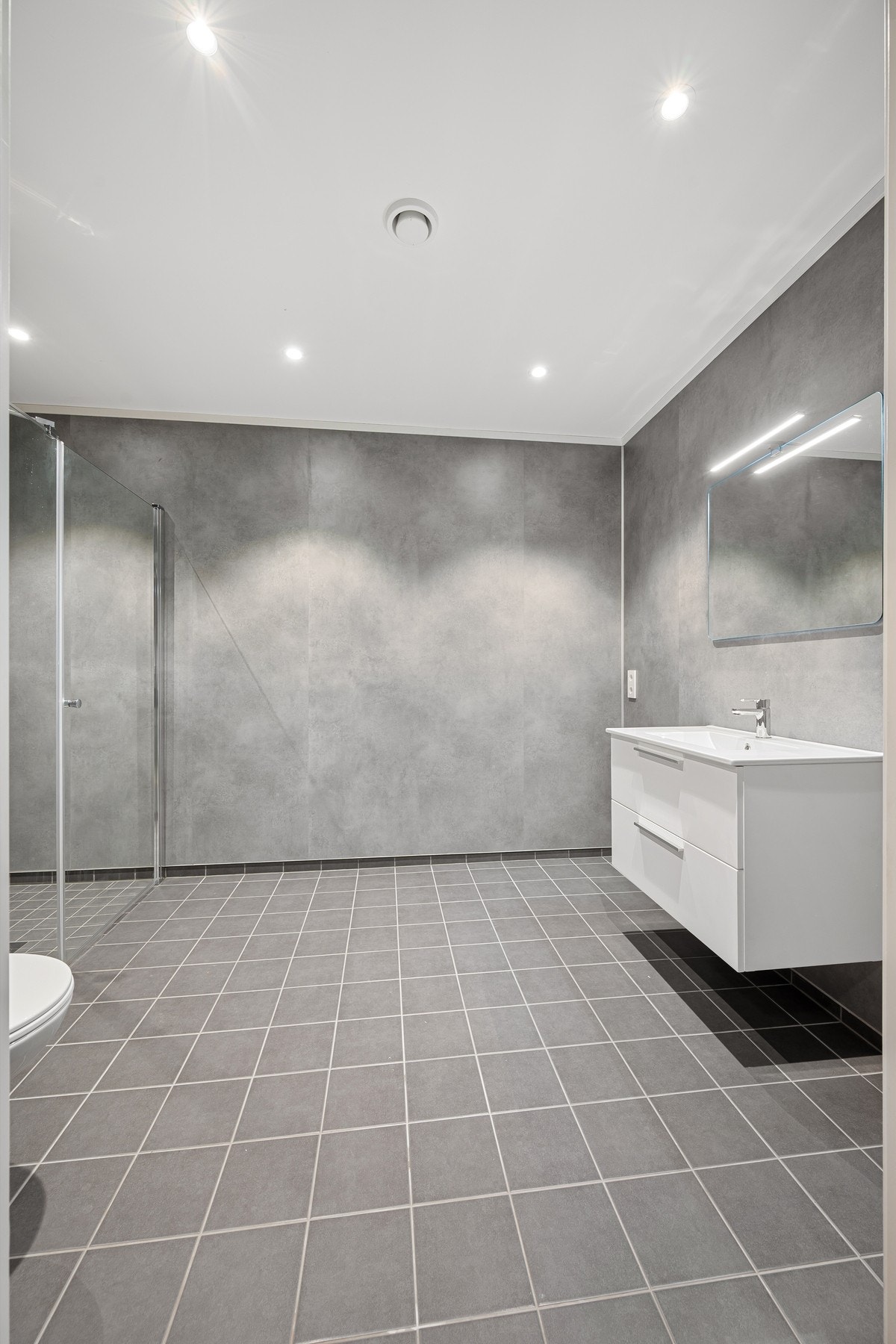 Lekkert bad med flislagt gulv og varmekabler Galleribilde