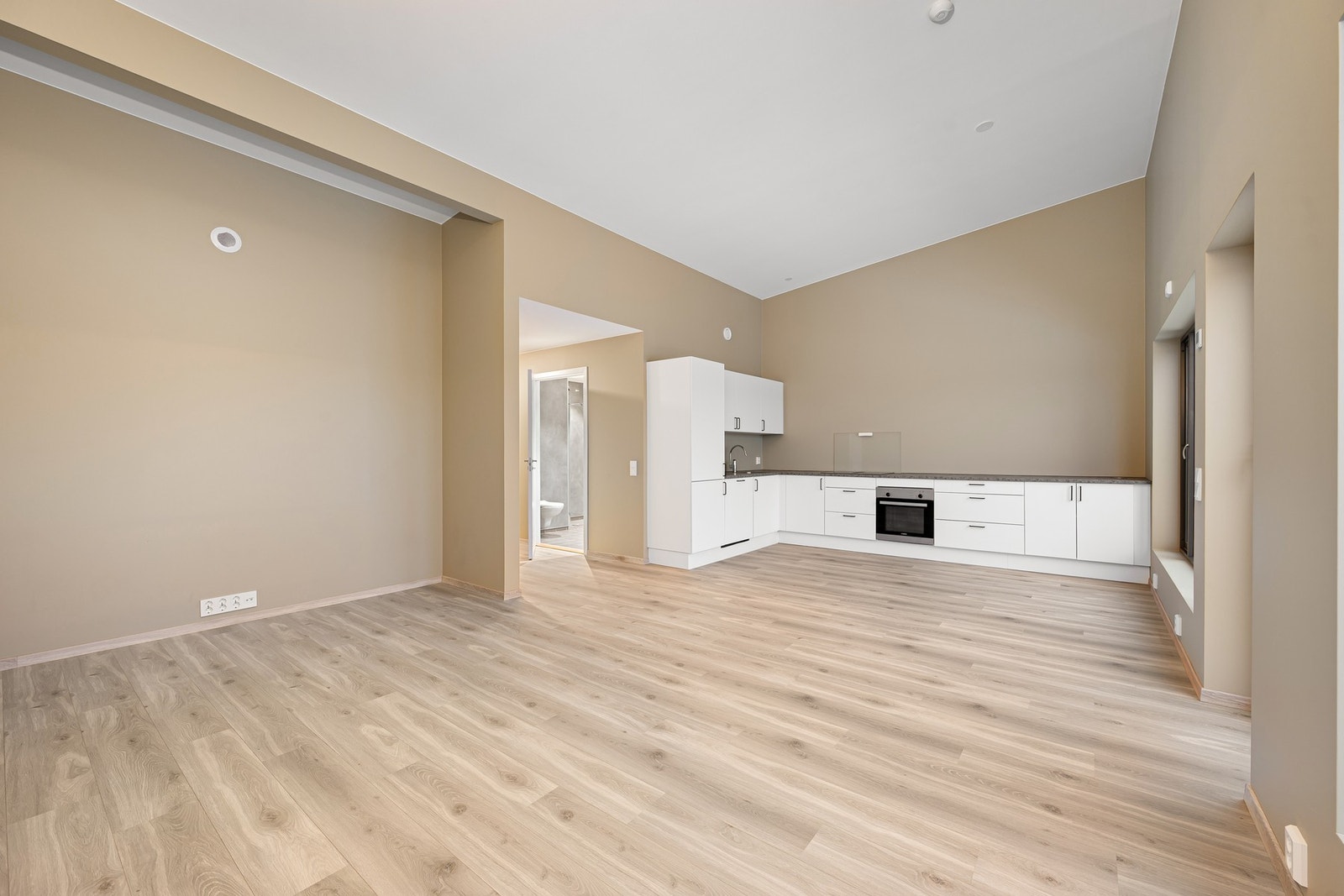 Et funksjonelt kjøkkenet med god benkeplass og skap for praktisk oppbevaring Galleribilde