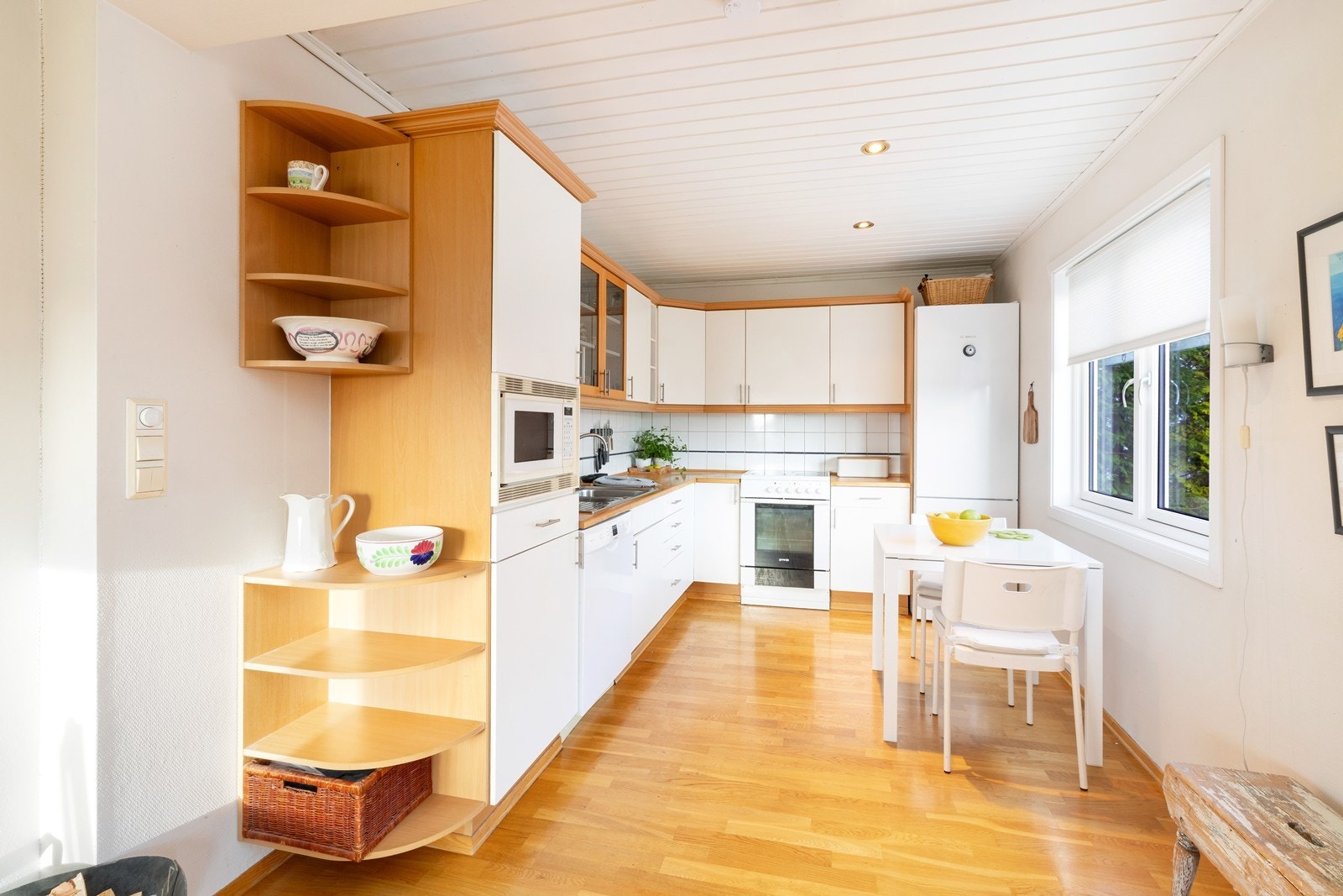 Hvit skapinnredning med fliser over benk. Oppvaskmaskin, kjøl/frys og komfyr medfølger bare etter nærmere avtale Galleribilde