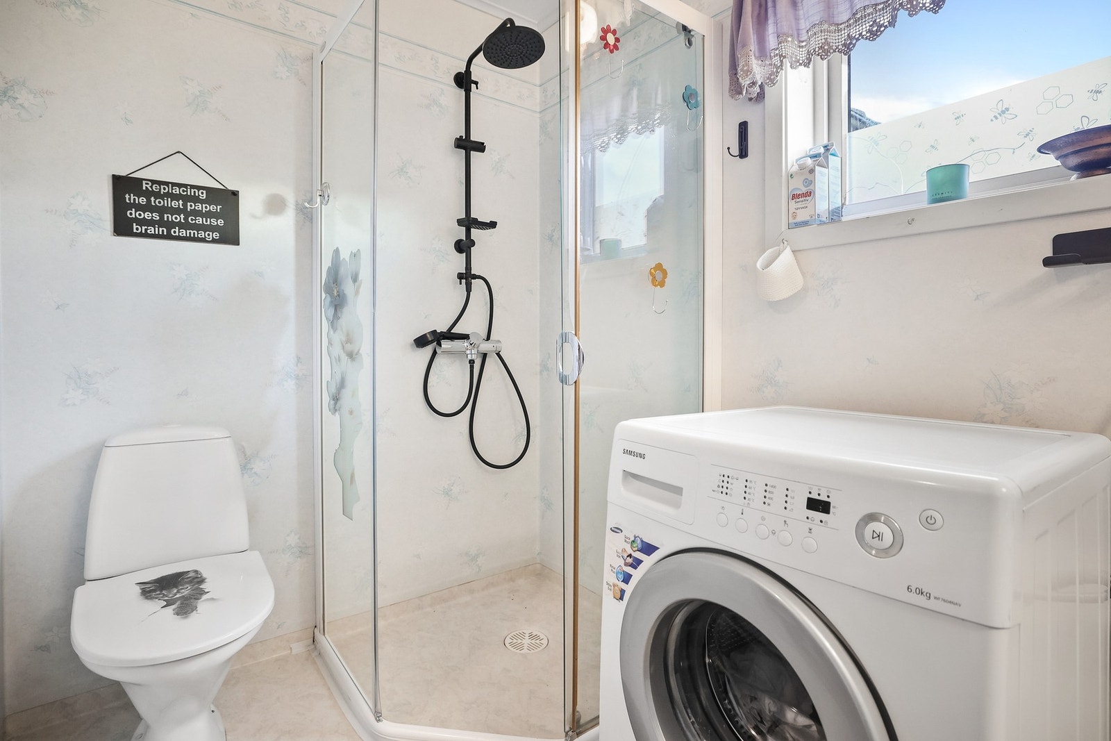 Baderommet inneholder dusjnisje med glassvegg og glassdør, gulvstående toalett og opplegg for vaskemaskin. Galleribilde