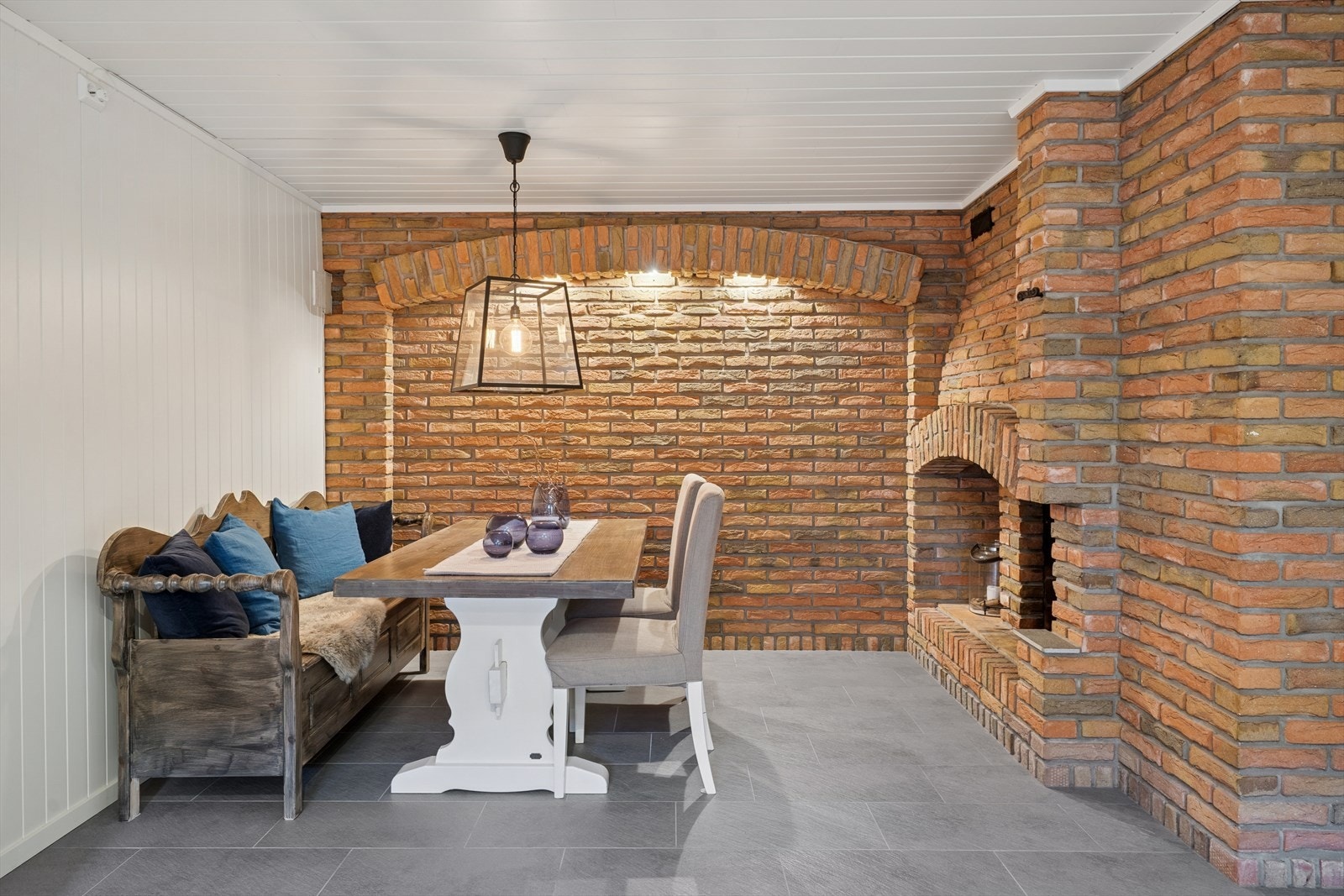 Hyggelig peishjørne med bord og sitteplasser, ideelt for avslappende stunder Galleribilde