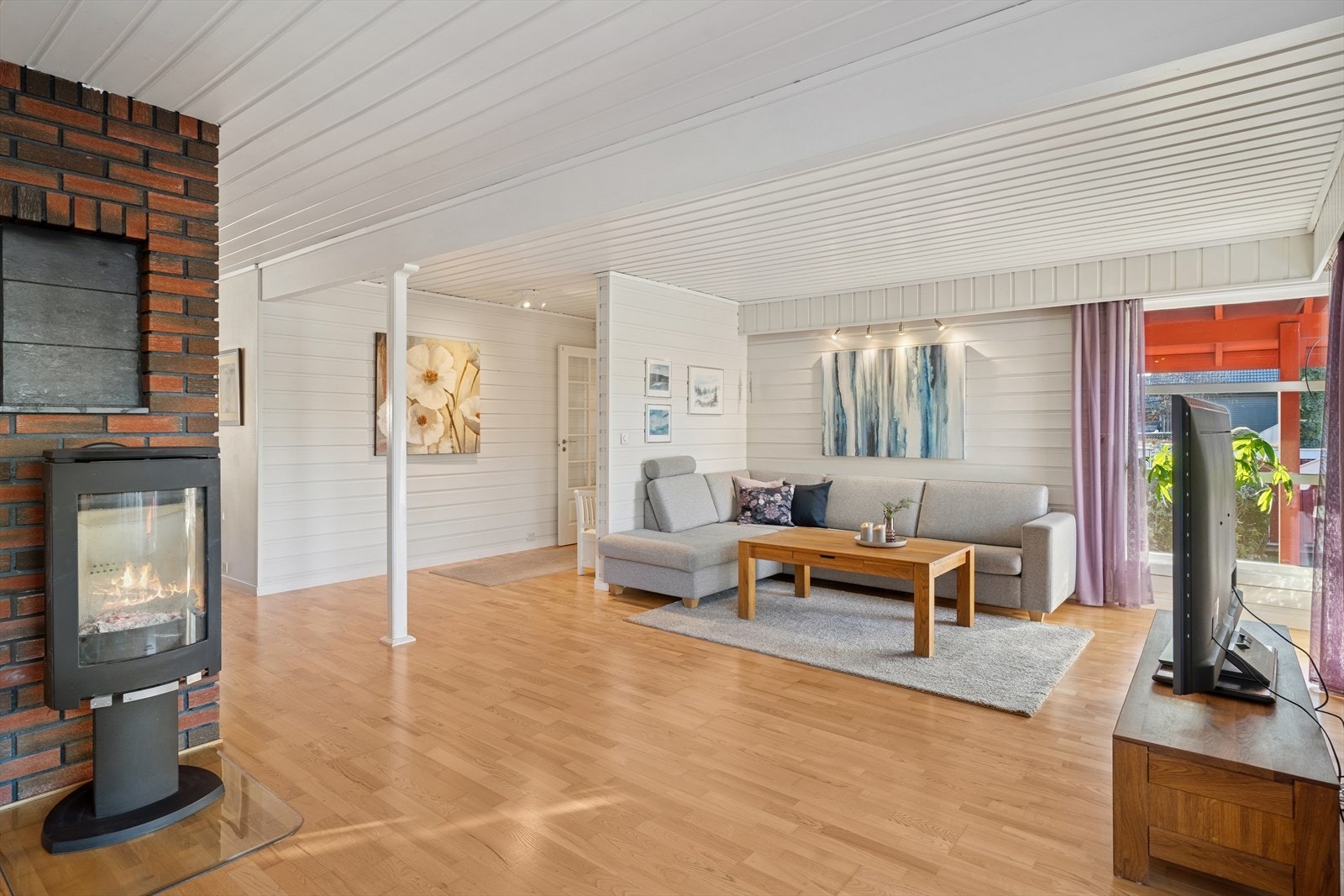 Innbydende stue med godt lys fra store vindusflater Galleribilde