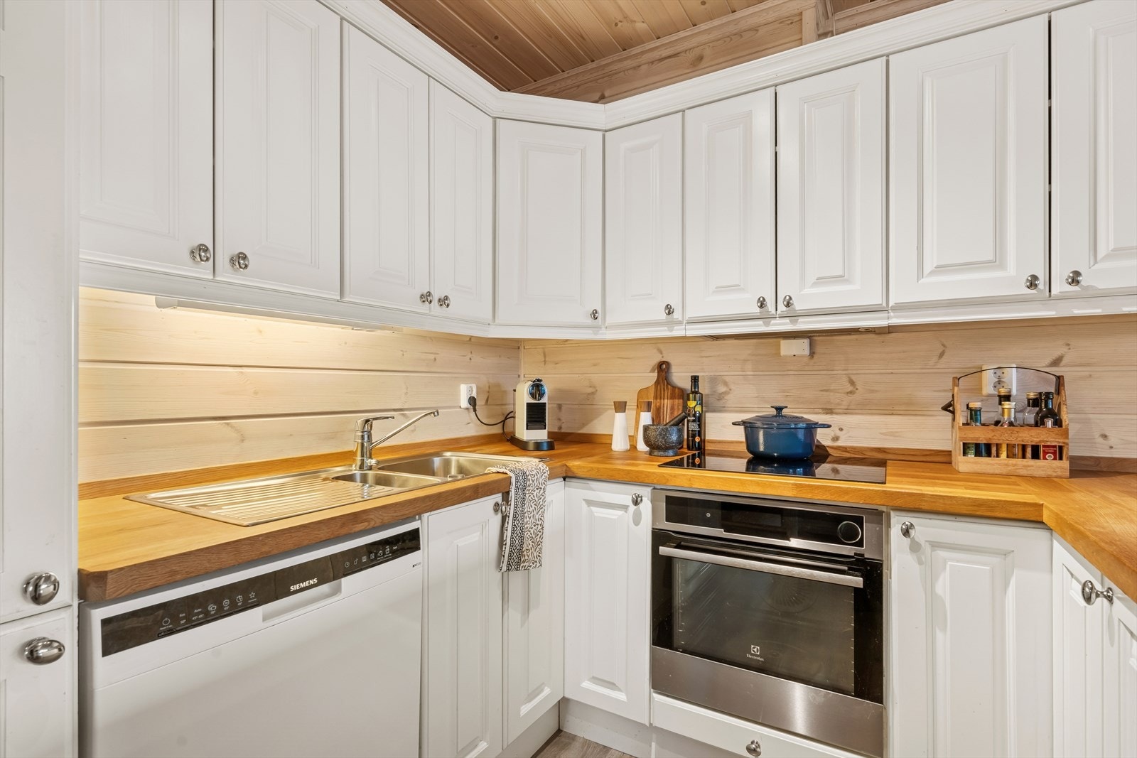 Kjøkkenet fra 2012 har en innredning med malte, profilerte fronter og tykke benkeplater i heltre eik, som gir godt med benke- og skapplass. Galleribilde