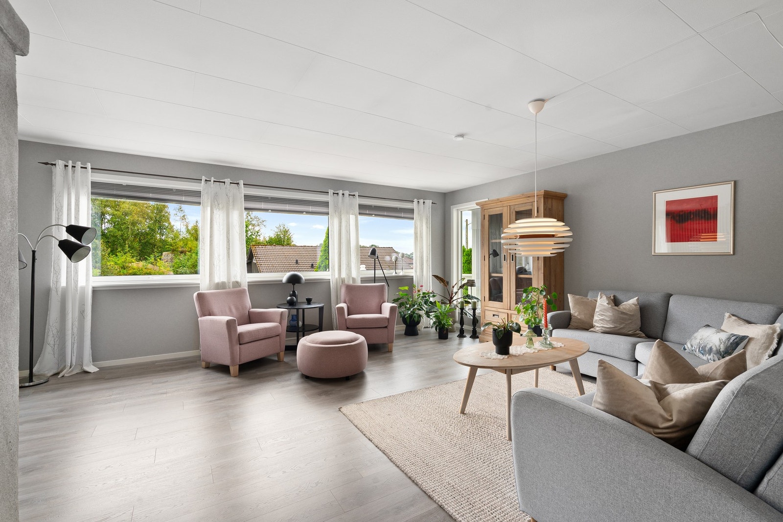 Behagelig stue med god romfølelse, store vinduer og en innredning som inviterer til ro og tilstedeværelse. Galleribilde