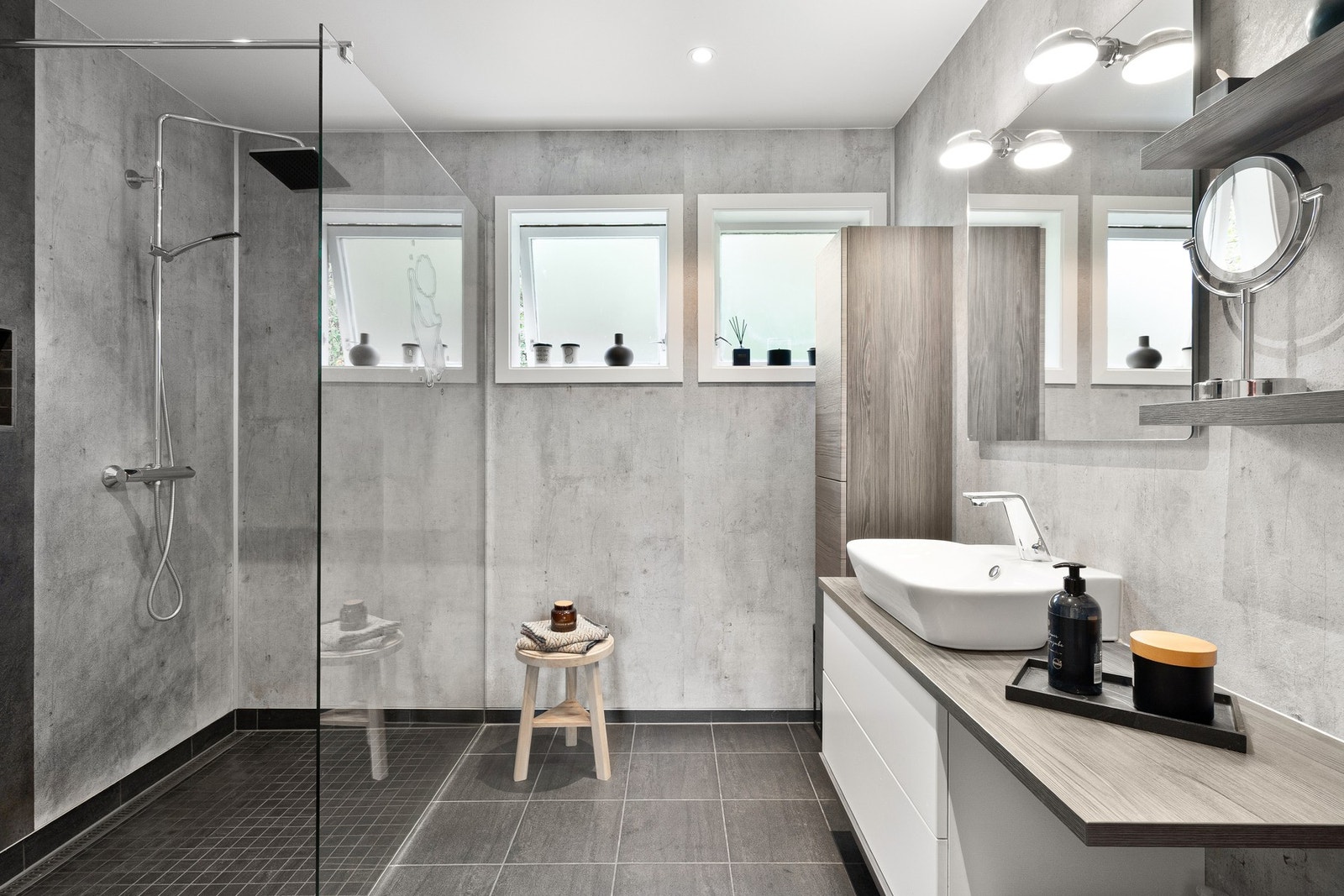 Stilrent baderom med dusjhjørne og en lun materialpalett som gir en rolig start på dagen. Galleribilde