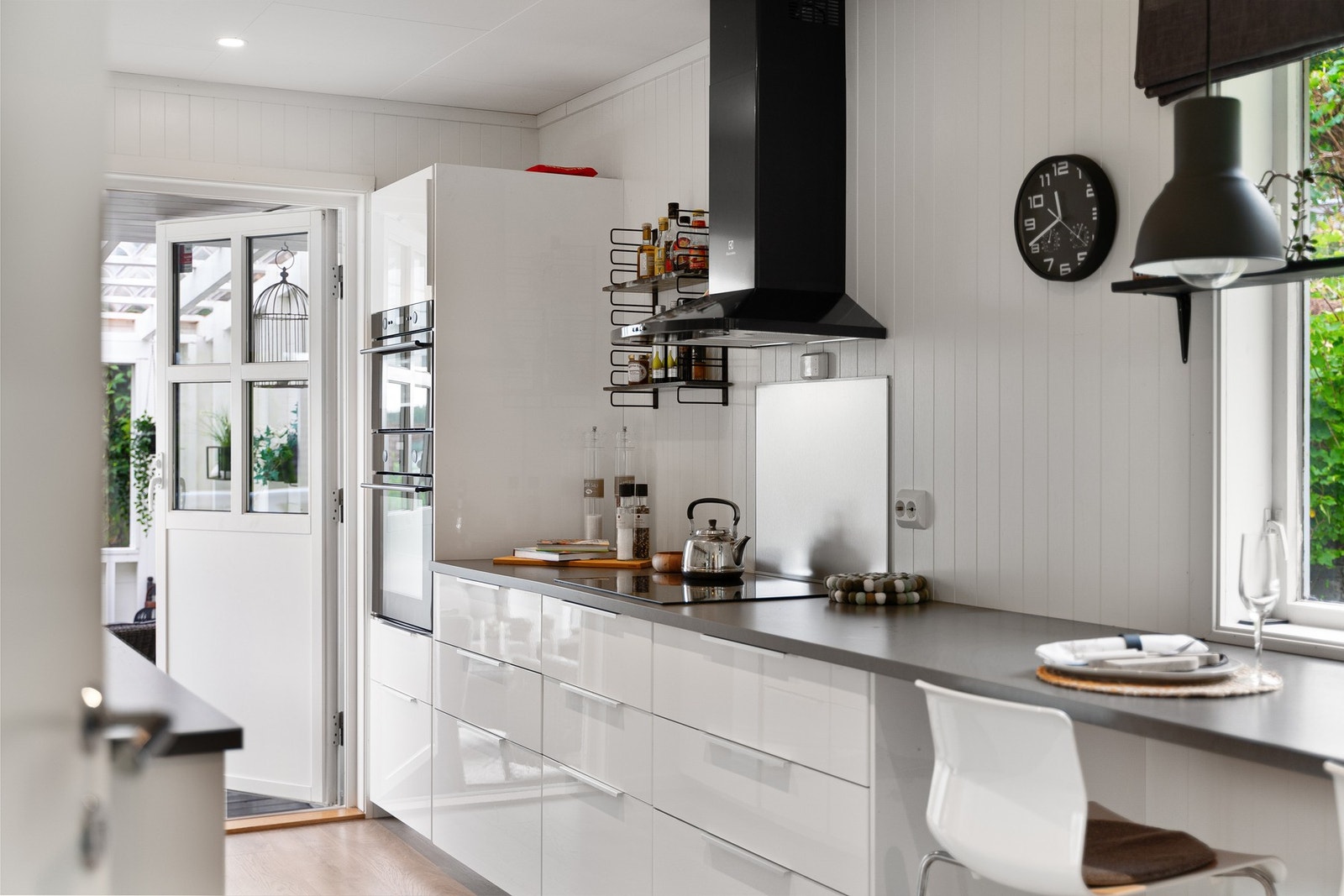 Kjøkkenet har praktiske arbeidsflater, integrerte hvitevarer og utgang til den overbygde uteplassen. Galleribilde