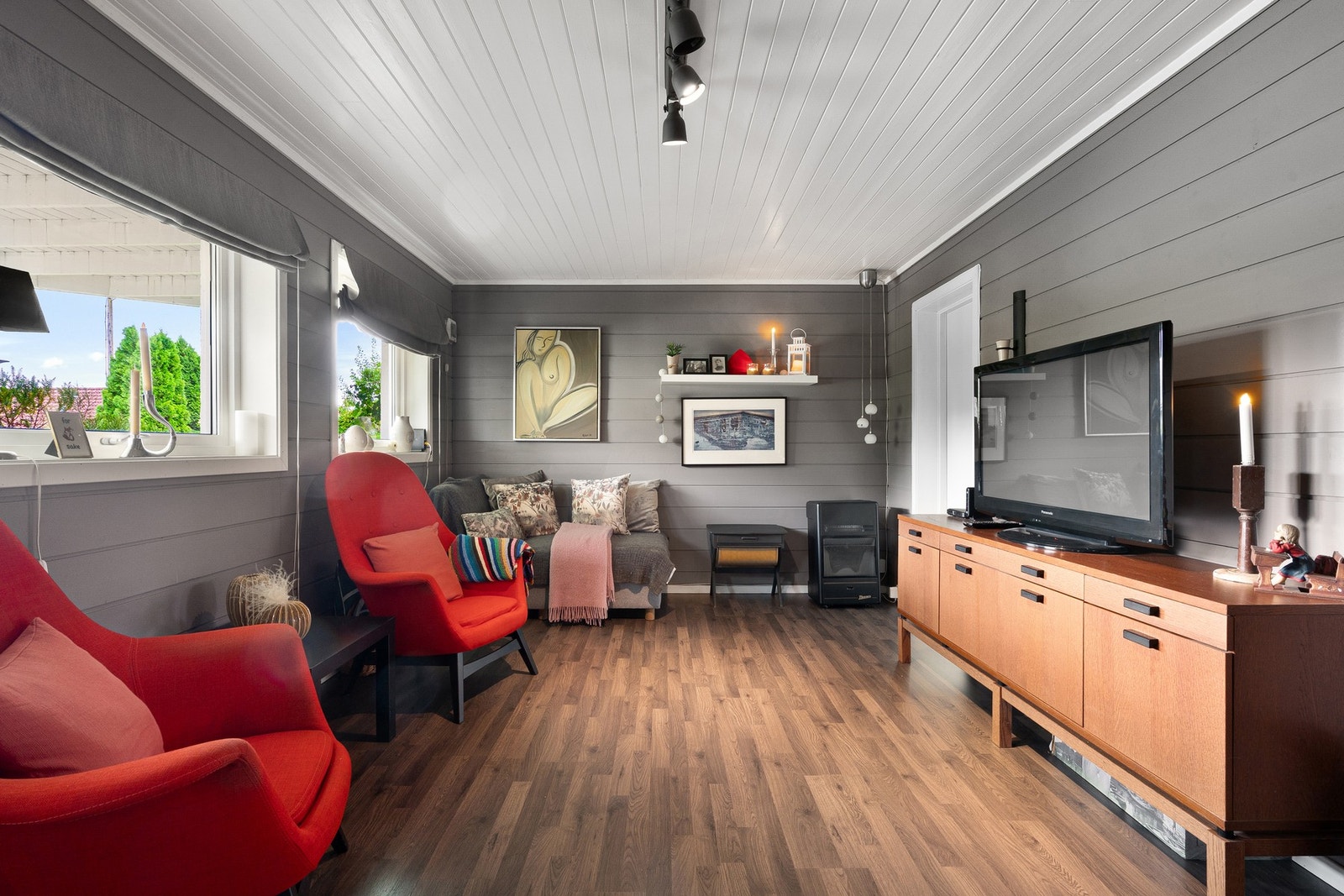 Koselig kjellerstue med varme fargetoner, store vinduer og plass til både avslapning og underholdning. Galleribilde