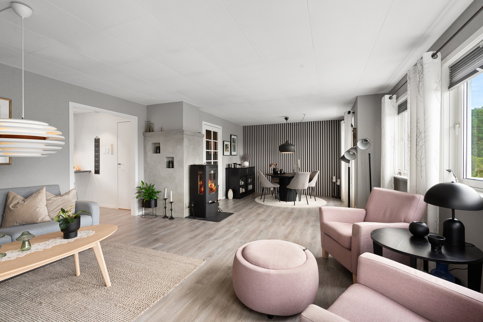 Åpen og stilfull stue og spisestueløsning med peisovn som gir både varme og karakter til rommet. Galleribilde