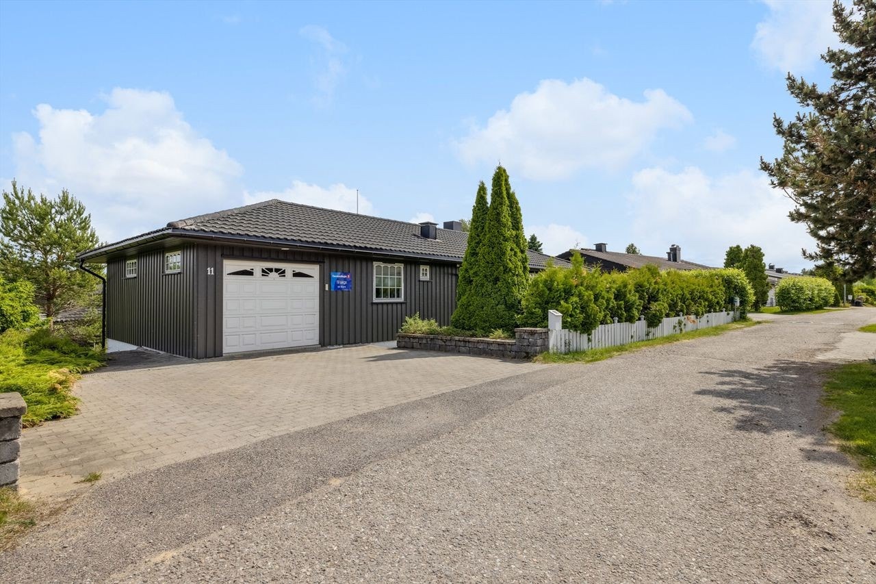 Belegningsstein på gårdsplass, gangarealer og trapp til nedre nivå på eiendommen. Gulvet i garasjen er flislagt Galleribilde