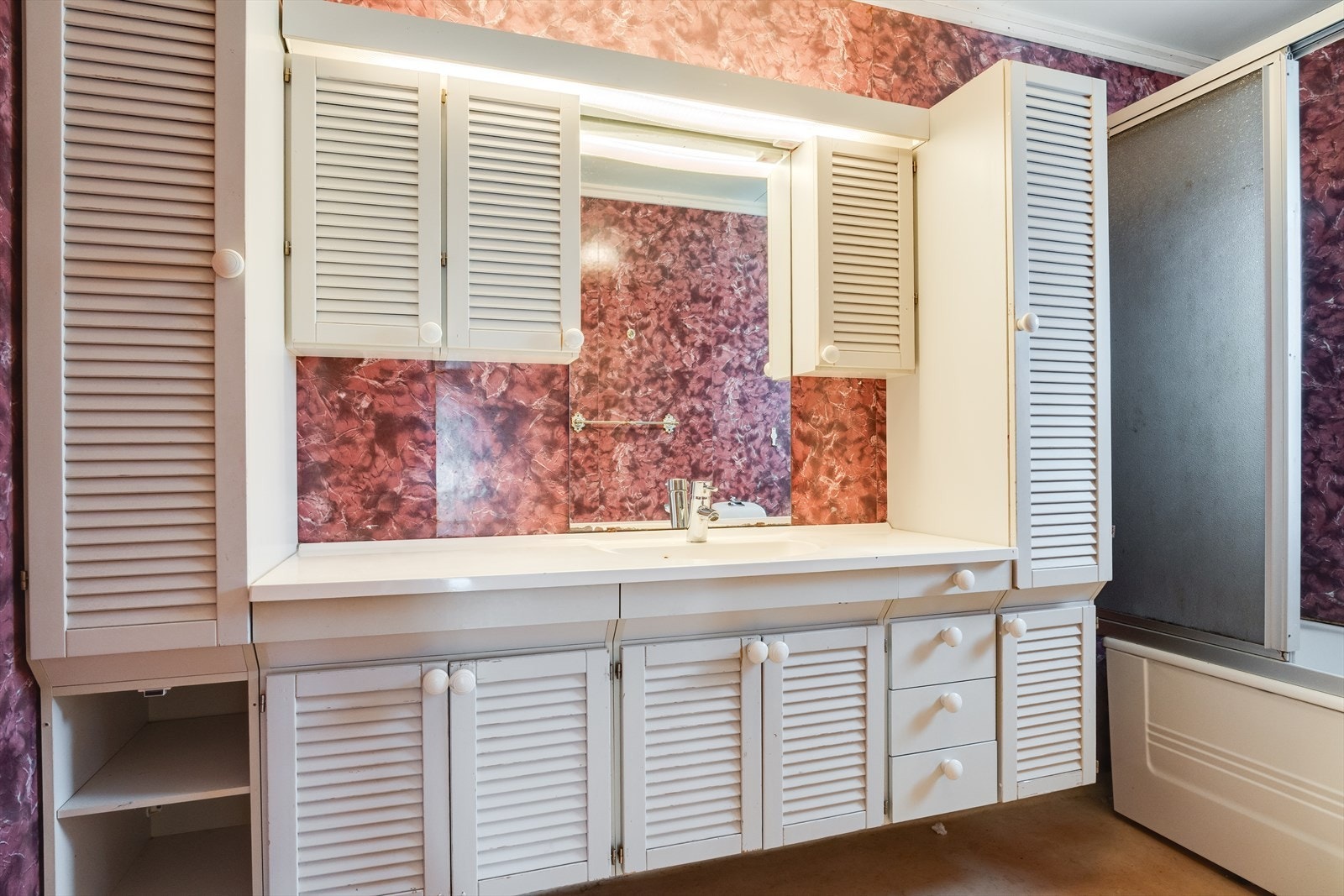 Stort baderom med badekar og baderomsseksjon med mye oppbevaringsplass. Galleribilde