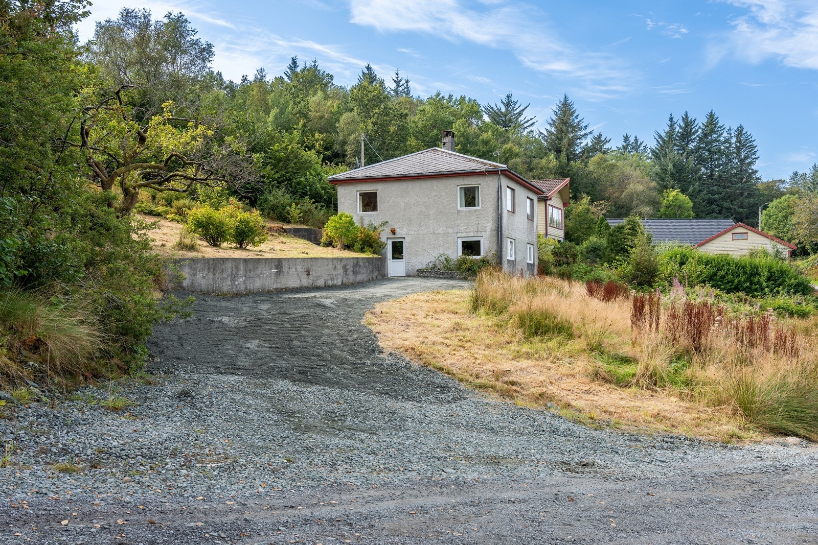 Oppkjørsel i grus, med flere biloppstillingsplasser. Galleribilde