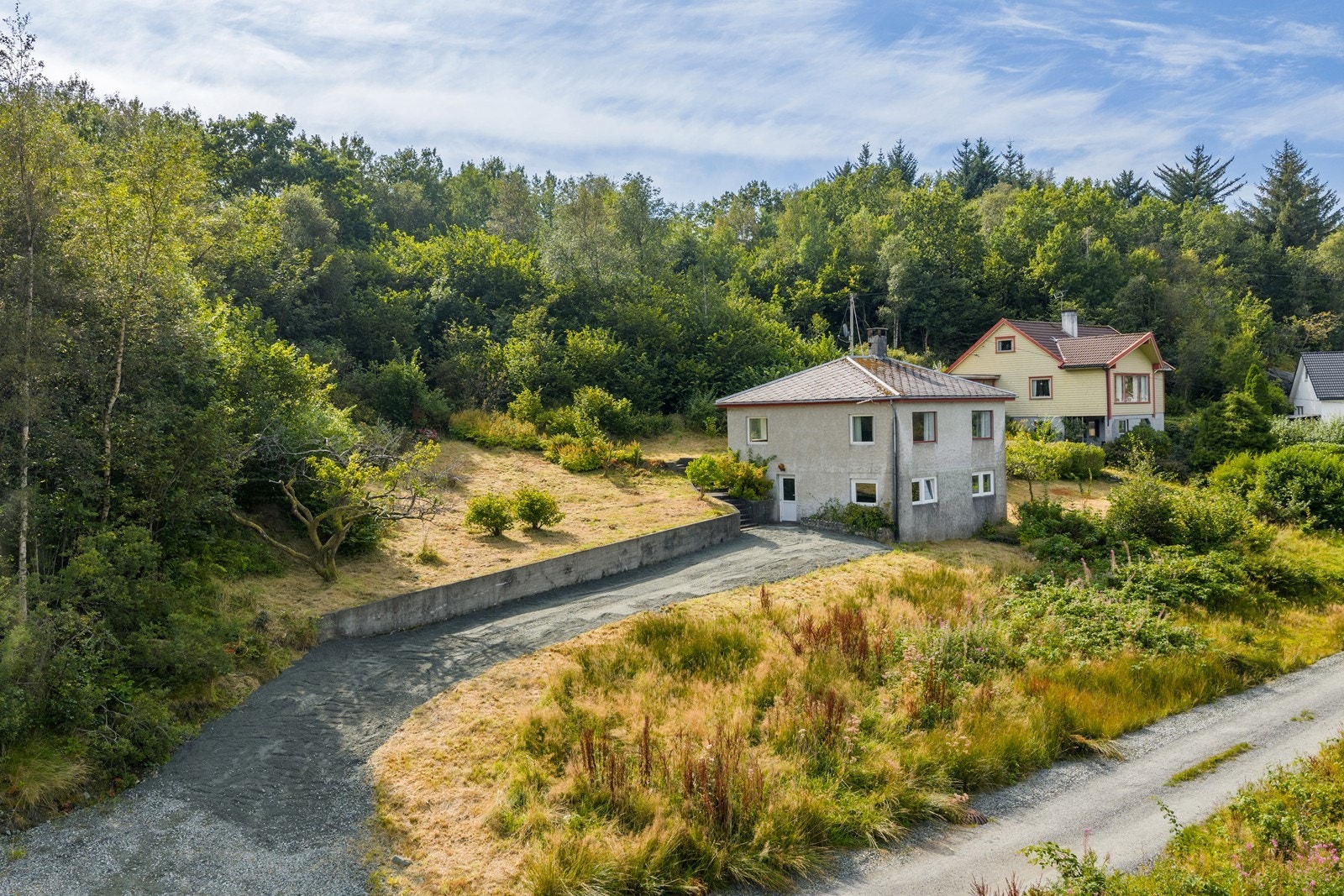 Området rundt er frodig med beplantning og skog samt plen rundt boligen. Galleribilde