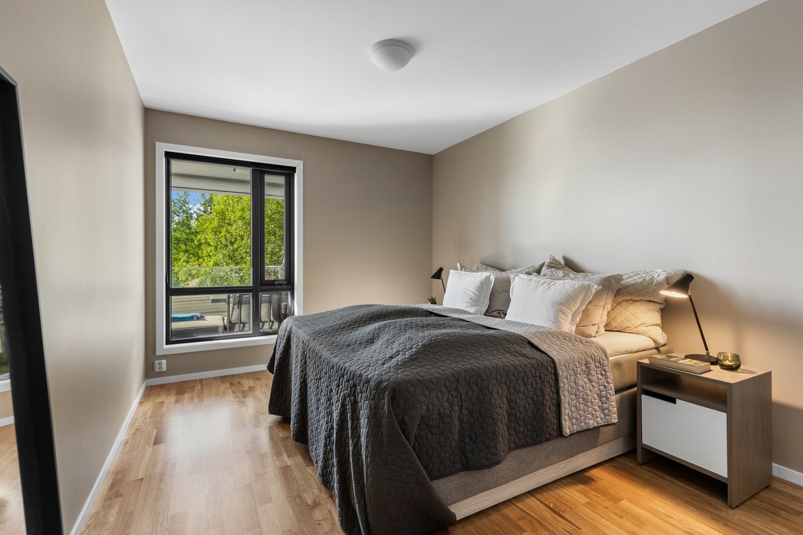 Hovedsoverommet fremstår lyst og harmonisk med moderne uttrykk og utsikt mot grønne omgivelser. Galleribilde