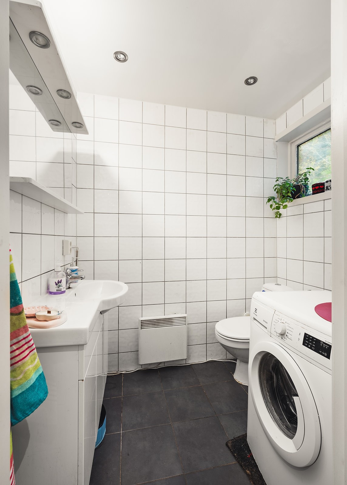 Pent, flislagt baderom med opplegg for vaskemaskin. Galleribilde