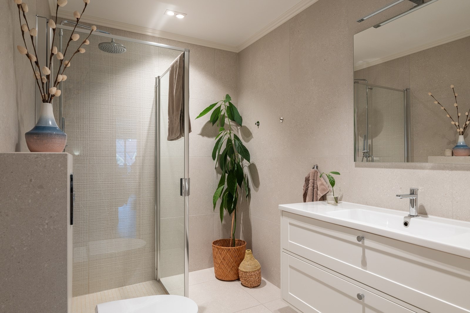 I 1. etasje ligger et flislagt bad med dusjhjørne, vegghengt toalett og servant med underskap. Galleribilde