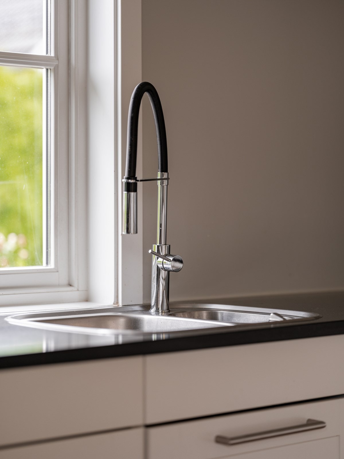 Nedfelt oppvaskkum har ettgreps svingbart blandebatteri med dusjfunksjon. Galleribilde