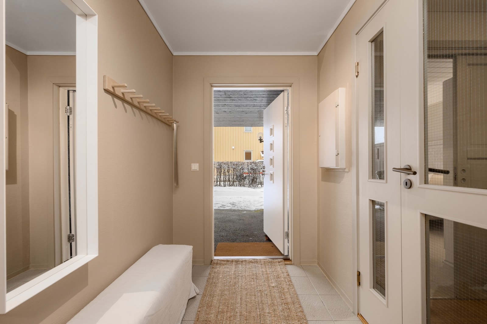 Lyst vindfang med flislagt gulv - Direkte tilgang til garderoberom/bod gir smarte oppbevaringsmuligheter. Galleribilde