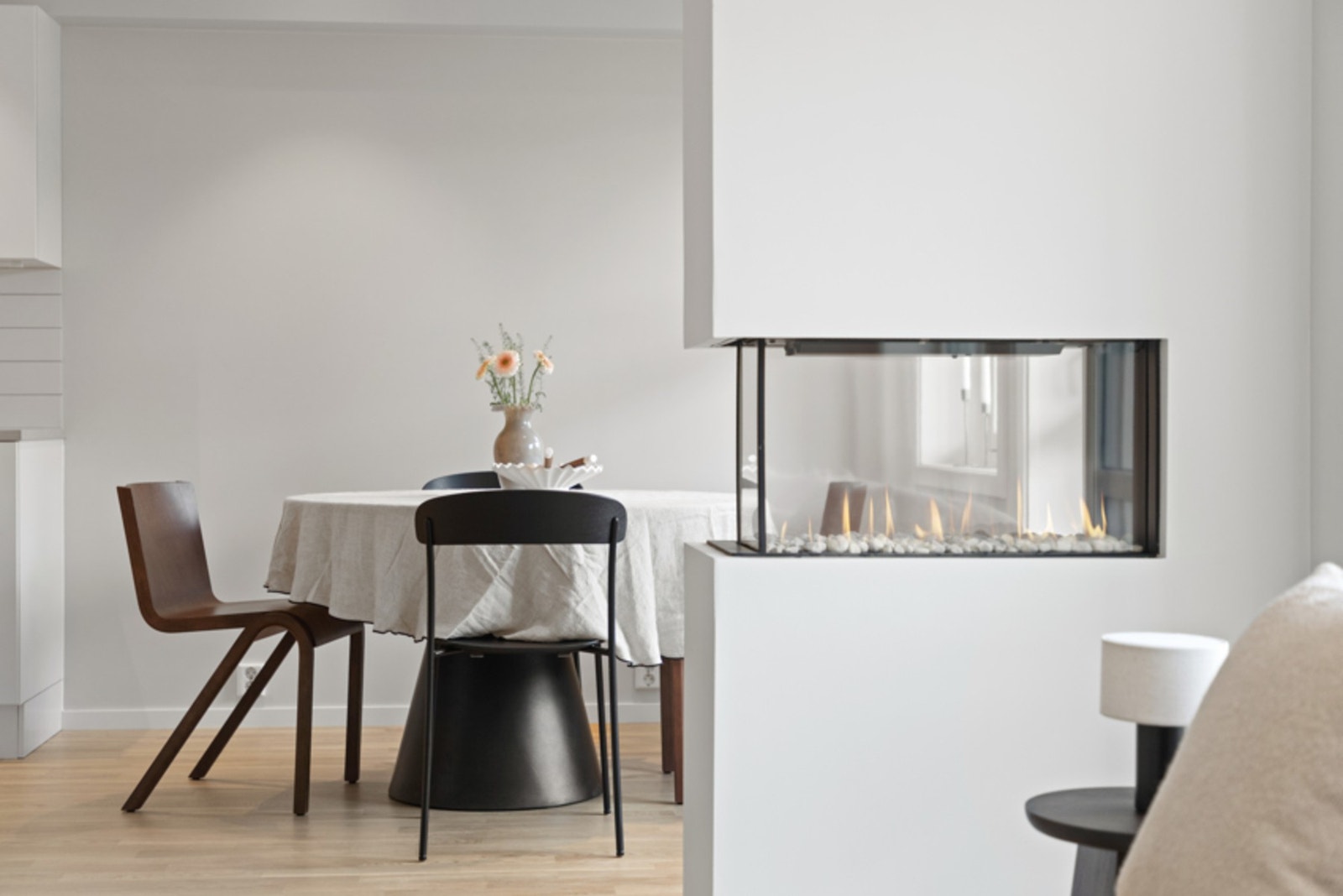 En lekker, innfelt gasspeis, med glass på tre sider, fungerer som en elegant romdeler mellom sonene og gir lun stemning Galleribilde