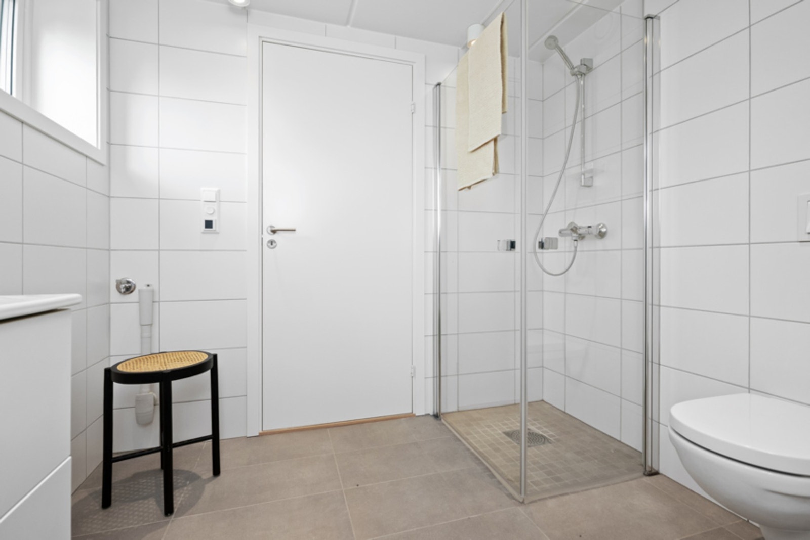 Rommet har samme overflater og innredning som badet oppe, samt dagslys fra et vindu og opplegg for vaskemaskin. Galleribilde