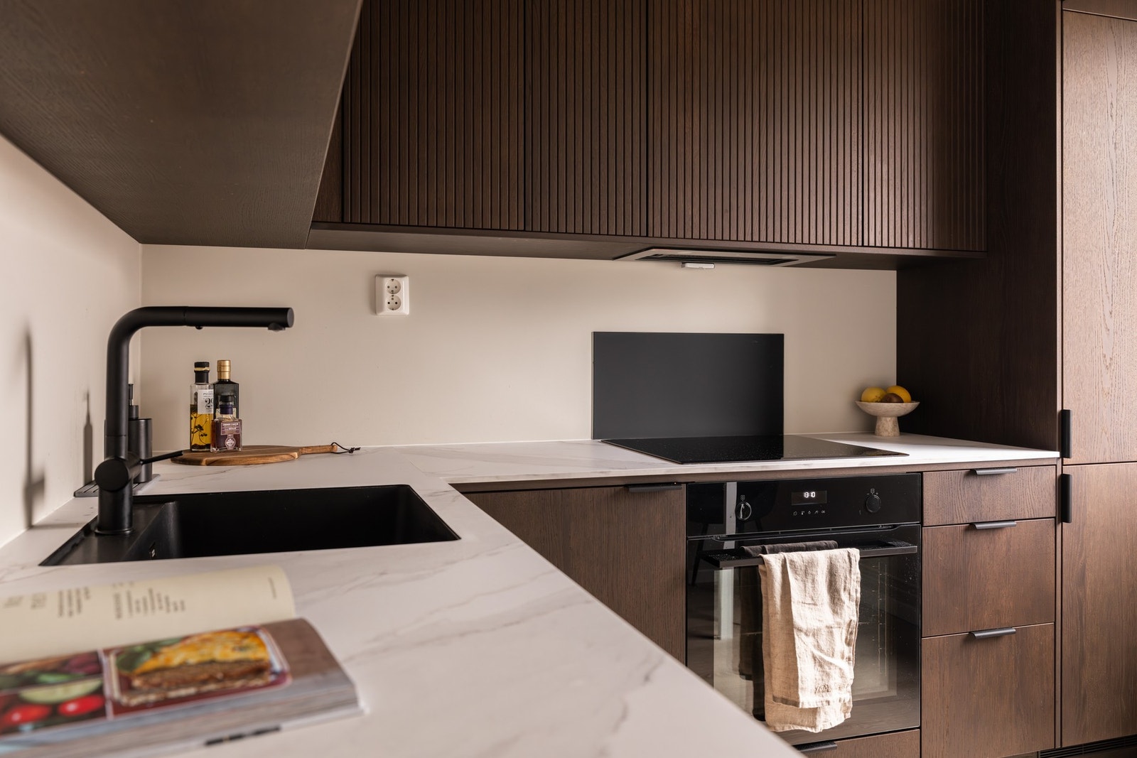 Kjøkkenet har et sømløst uttrykk med integrert oppvaskmaskin, kjøl/fryseskap, stekeovn og induksjon platetopp. Galleribilde