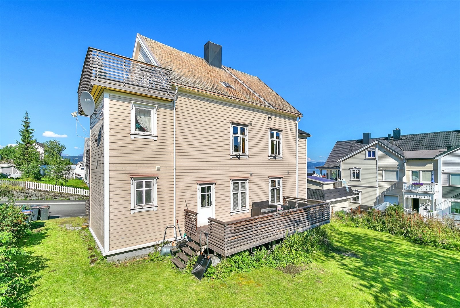 Stor og solrik tomt med terrasse og hage som kan benyttes av beboerne - perfekt for sommerdager og uteliv Galleribilde