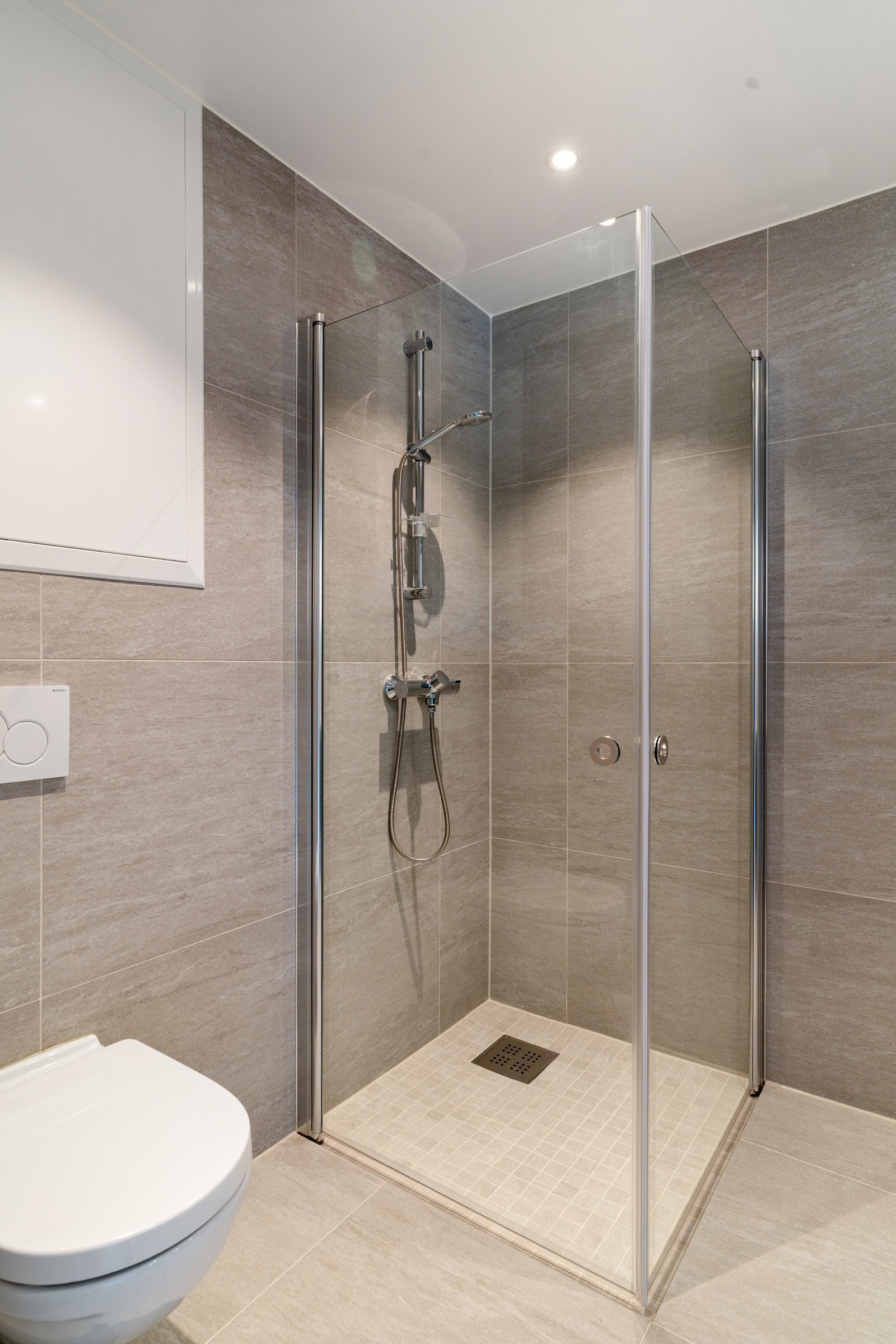 Vegghengt WC og dusjhjørne med innfellbare dusjdører. Galleribilde