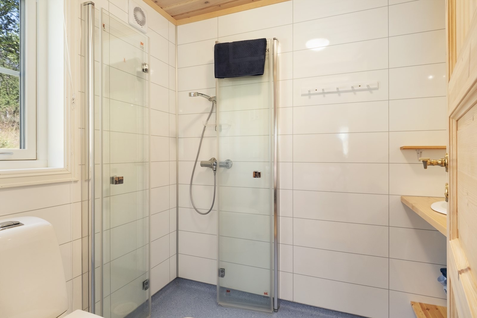 Badet har eit reint og tidsriktig uttrykk, med baderomsplater på veggane og belegg på golvet. Galleribilde