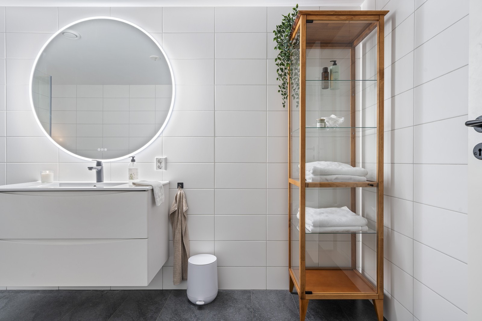 Badet er utstyrt med veggmontert toalett, seksjon med nedfelt servant og dusjhjørne med dusjvegger Galleribilde