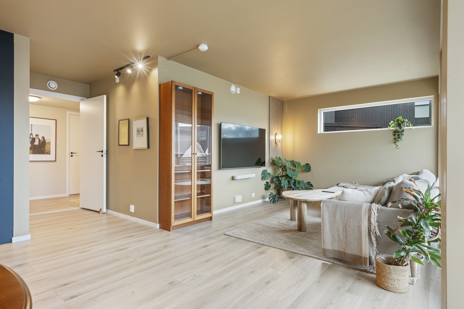 Leiligheten fremstår med gjennomgående delikate farger og stilrent enstavs laminat som gir et moderne og helhetlig uttrykk Galleribilde