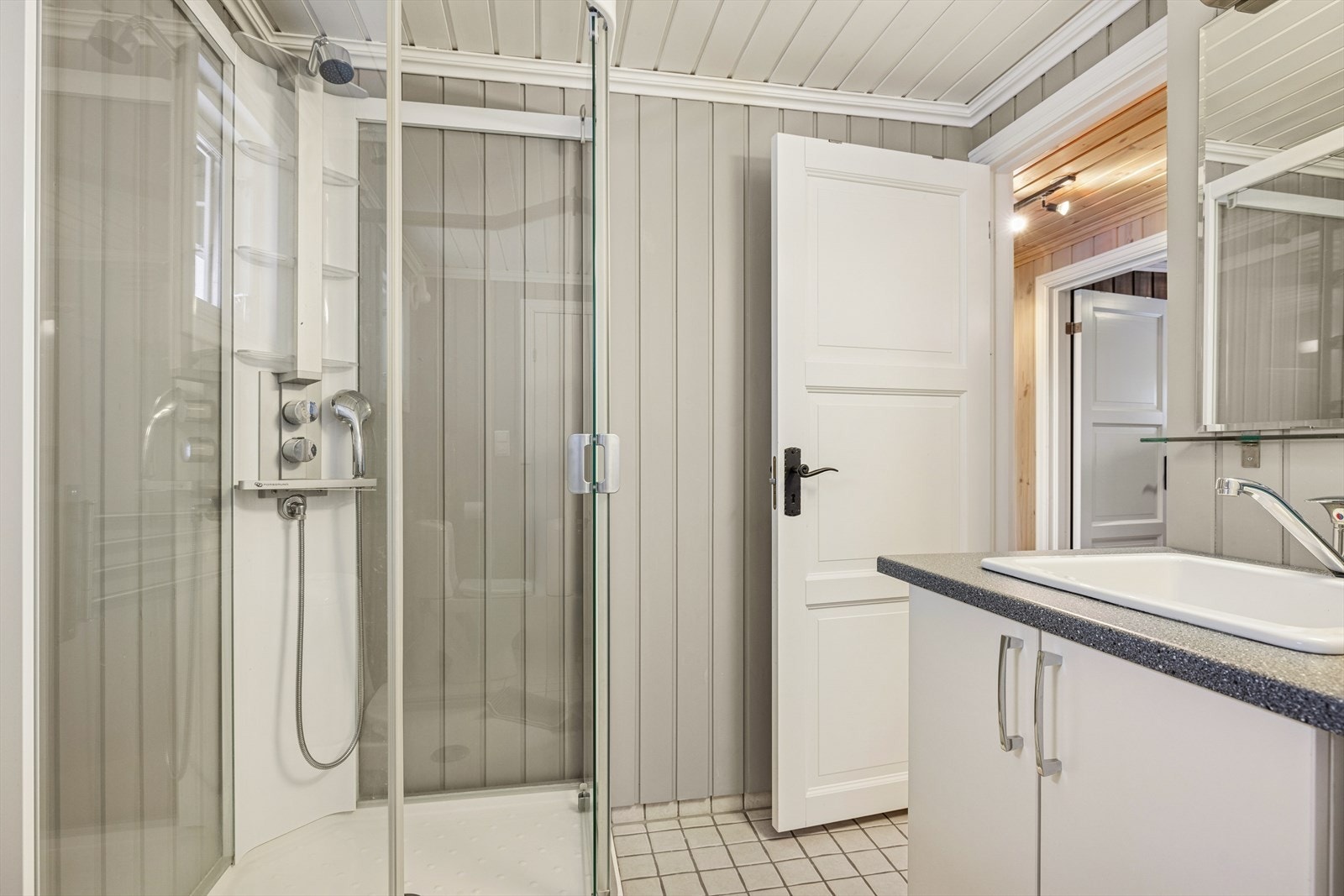 Det andre badet er av større størrelse og er innredet med servant i møbel, dusjkabinett og opplegg for vaskemaskin. Galleribilde