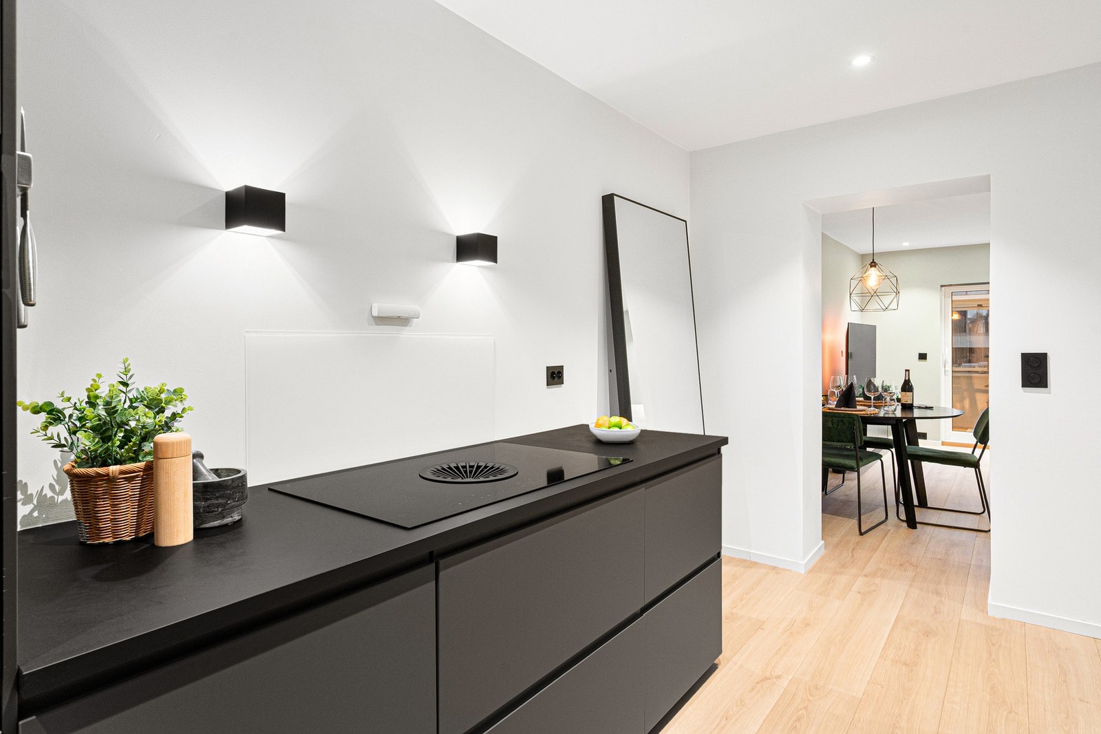 Naturlig skille mellom kjøkken og stue, noe som gir flere sosiale soner i leiligheten Galleribilde