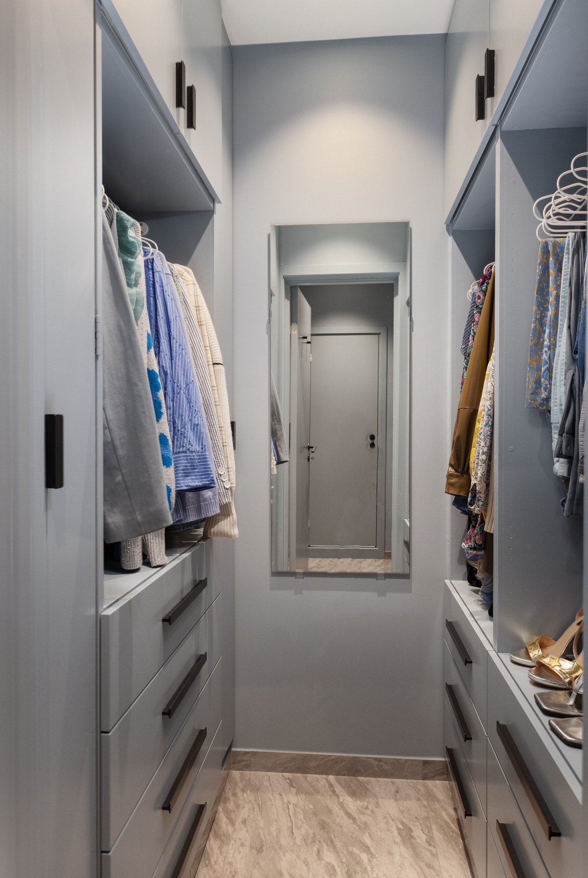 Rommet har plassbygde garderobeskap fra gulv til tak, varmekabler i gulvet og skjult oppbevaring for støvsuger. Galleribilde