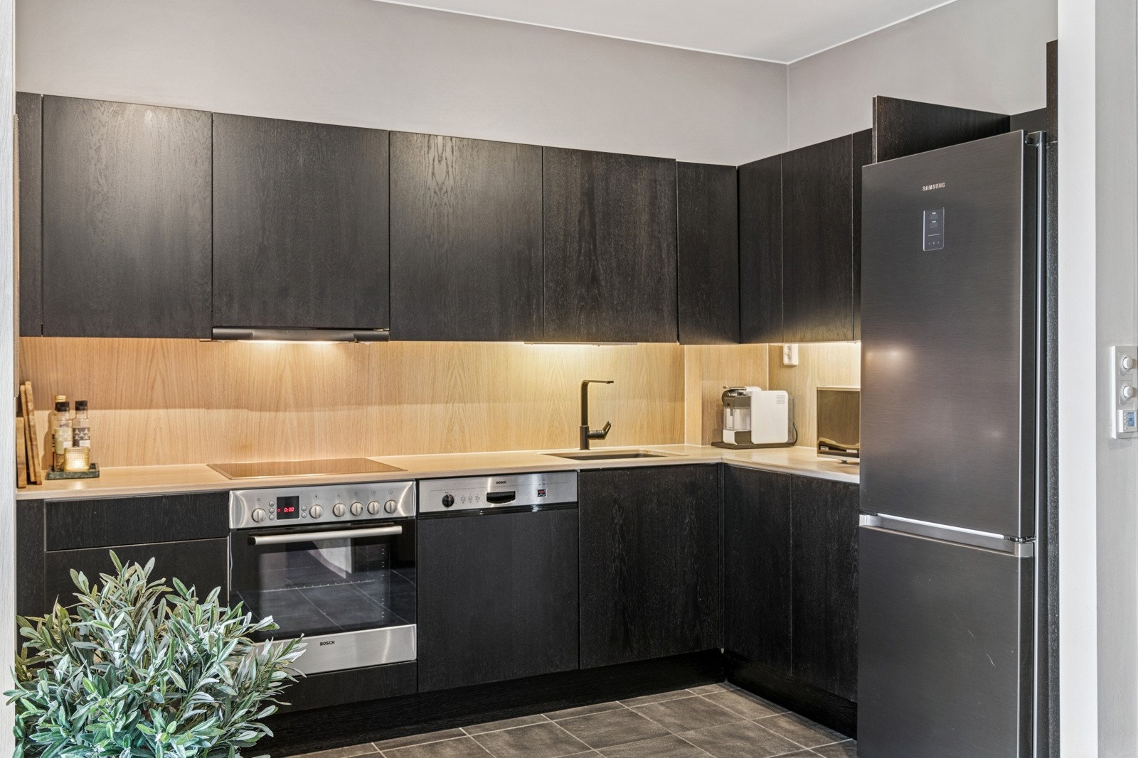 Det flotte kjøkkenet har fine arbeidsflater på benken og belysning over. Integrerte hvitevarer består av koketopp, stekeovn og oppvaskmaskin. Egen nisje til kjøl-/fryseskap. Galleribilde