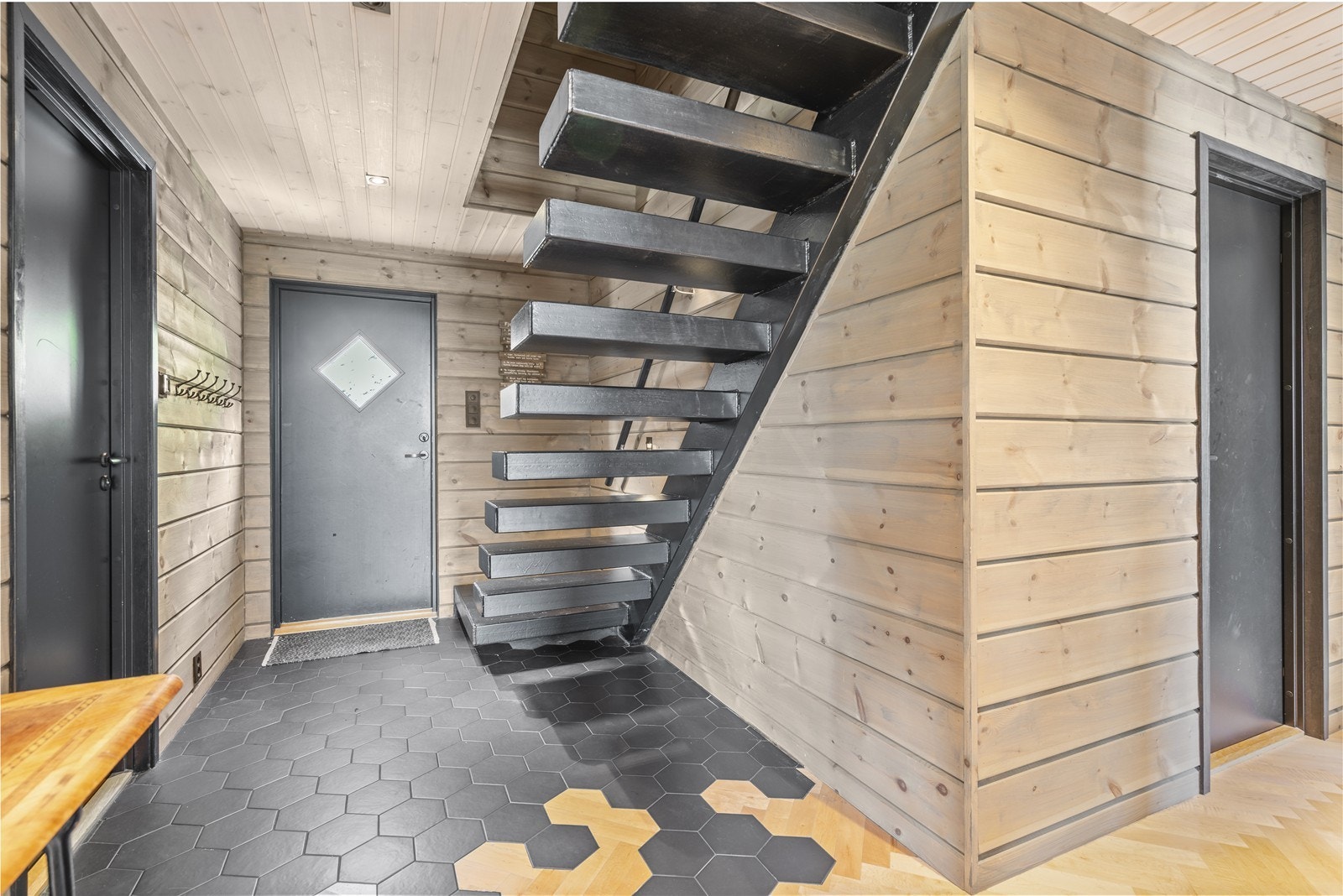 Gang med entrè som har god plass til oppheng av yttertøy. Den svevende trappen fungerer som et stilig blikkfang. Galleribilde