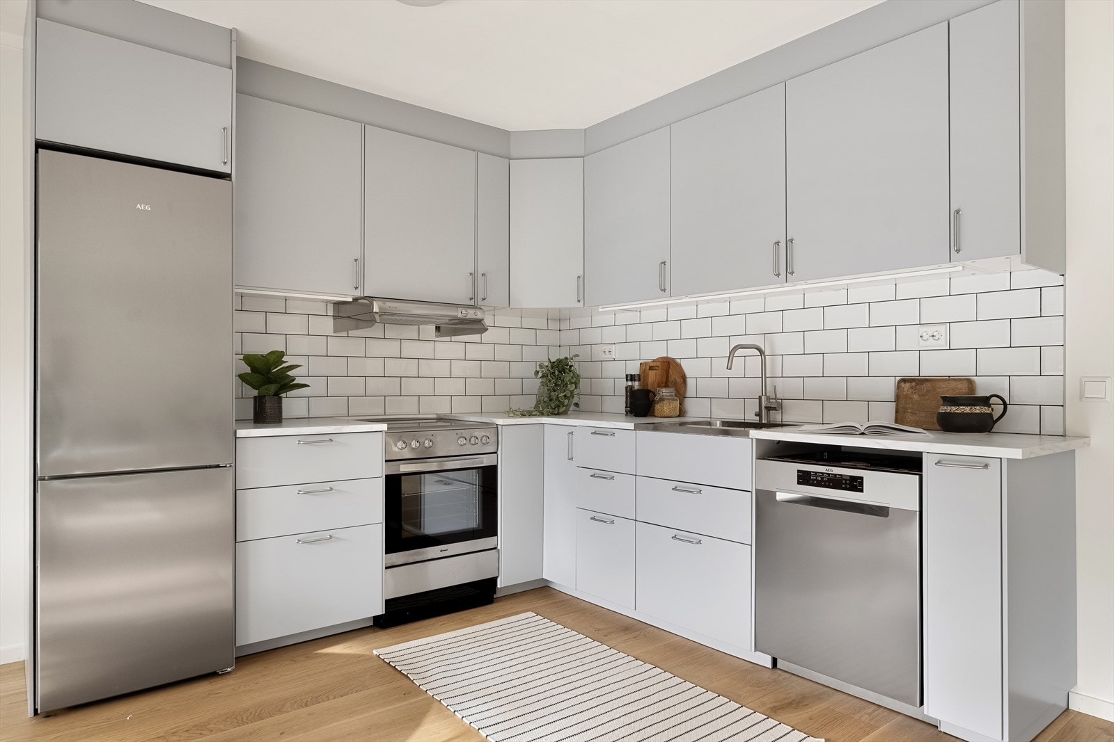 Stilrent kjøkken med glatte fronter og lys under overskap som gir godt arbeidslys. Galleribilde