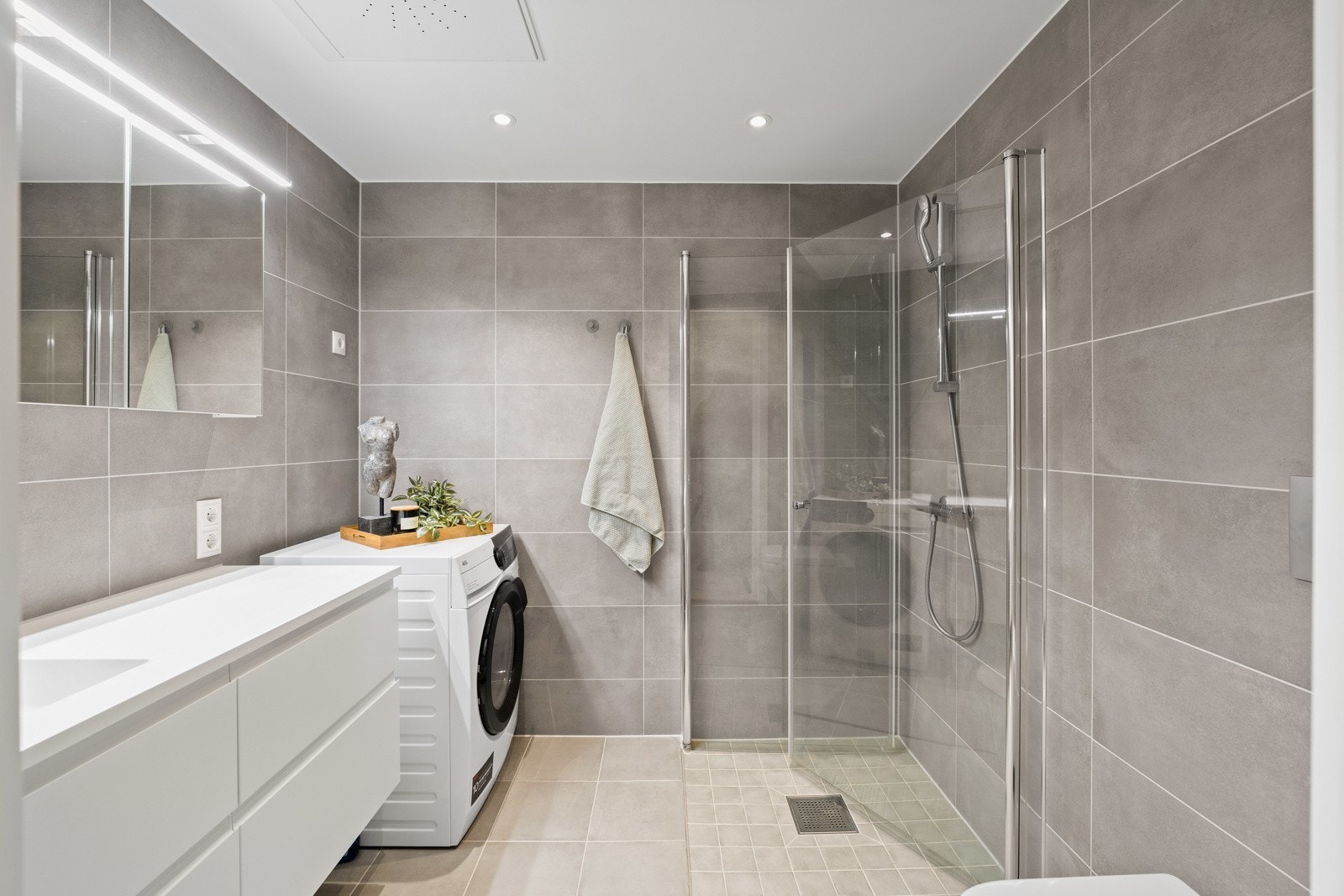 Lekkert og moderne bad fra byggeår med flislagt gulv og vegger. Galleribilde